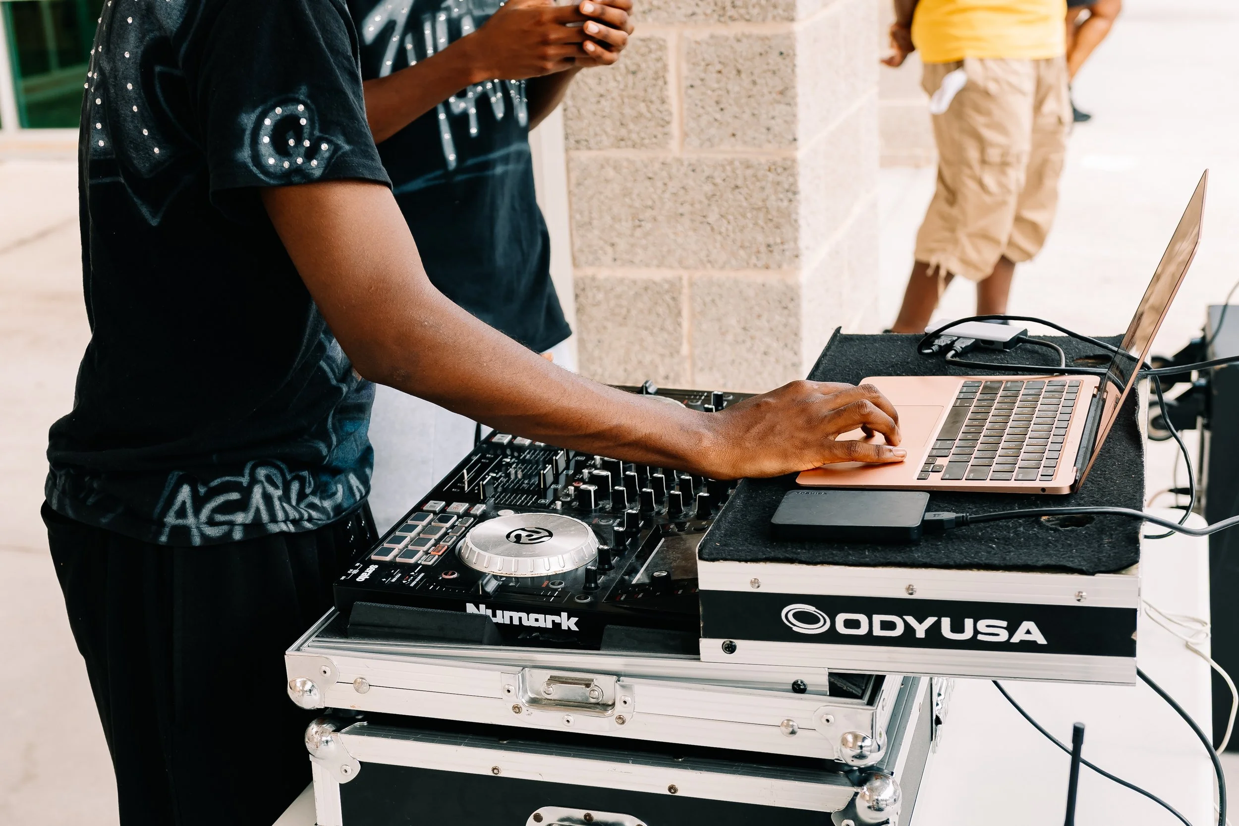 Close-up of a DJ using a laptop and mixing equipment to provide music during Chakira’s Cookout.