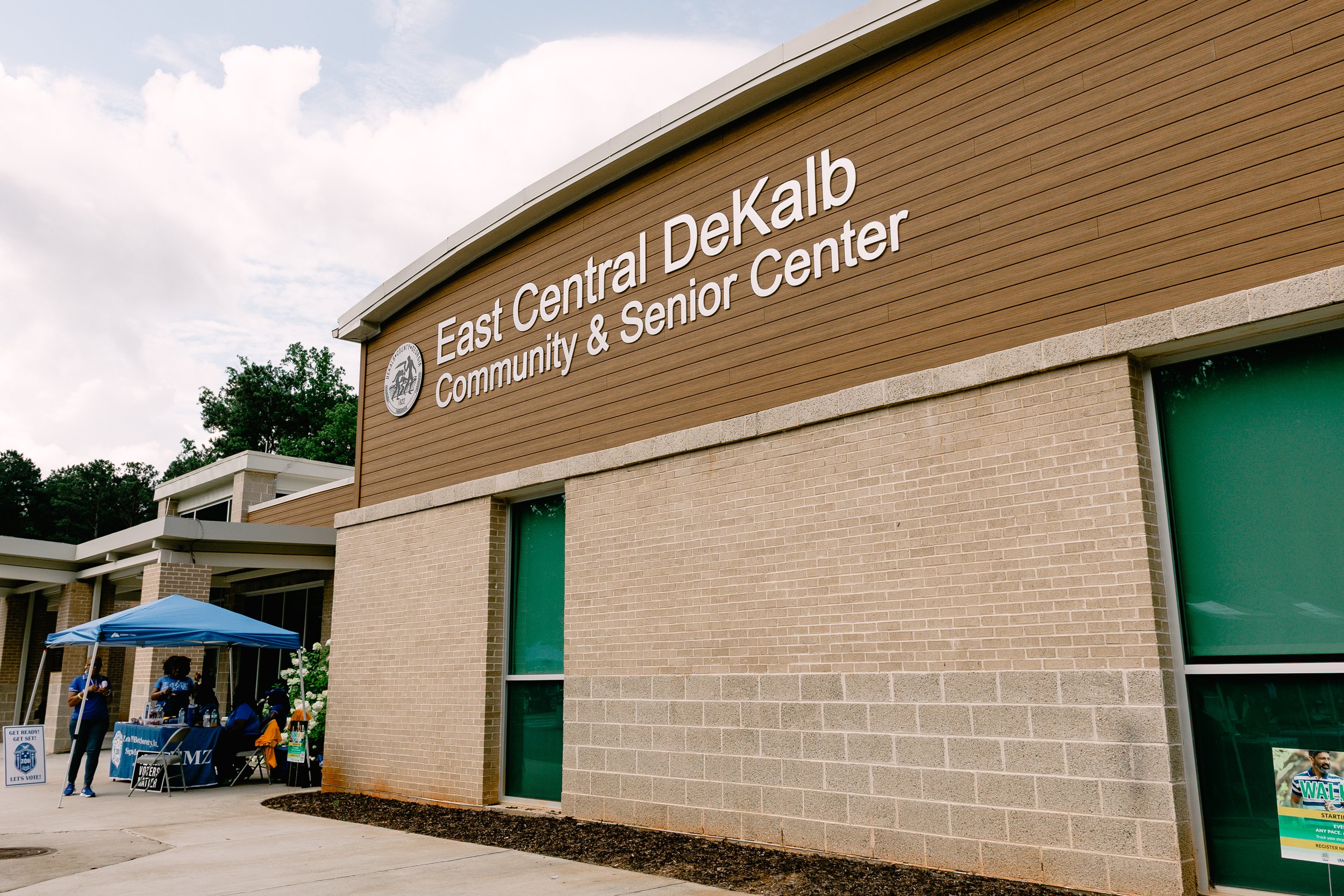 Exterior of the East Central DeKalb Community & Senior Center, site of Chakira’s Cookout, with event tables and tents visible near the entrance.