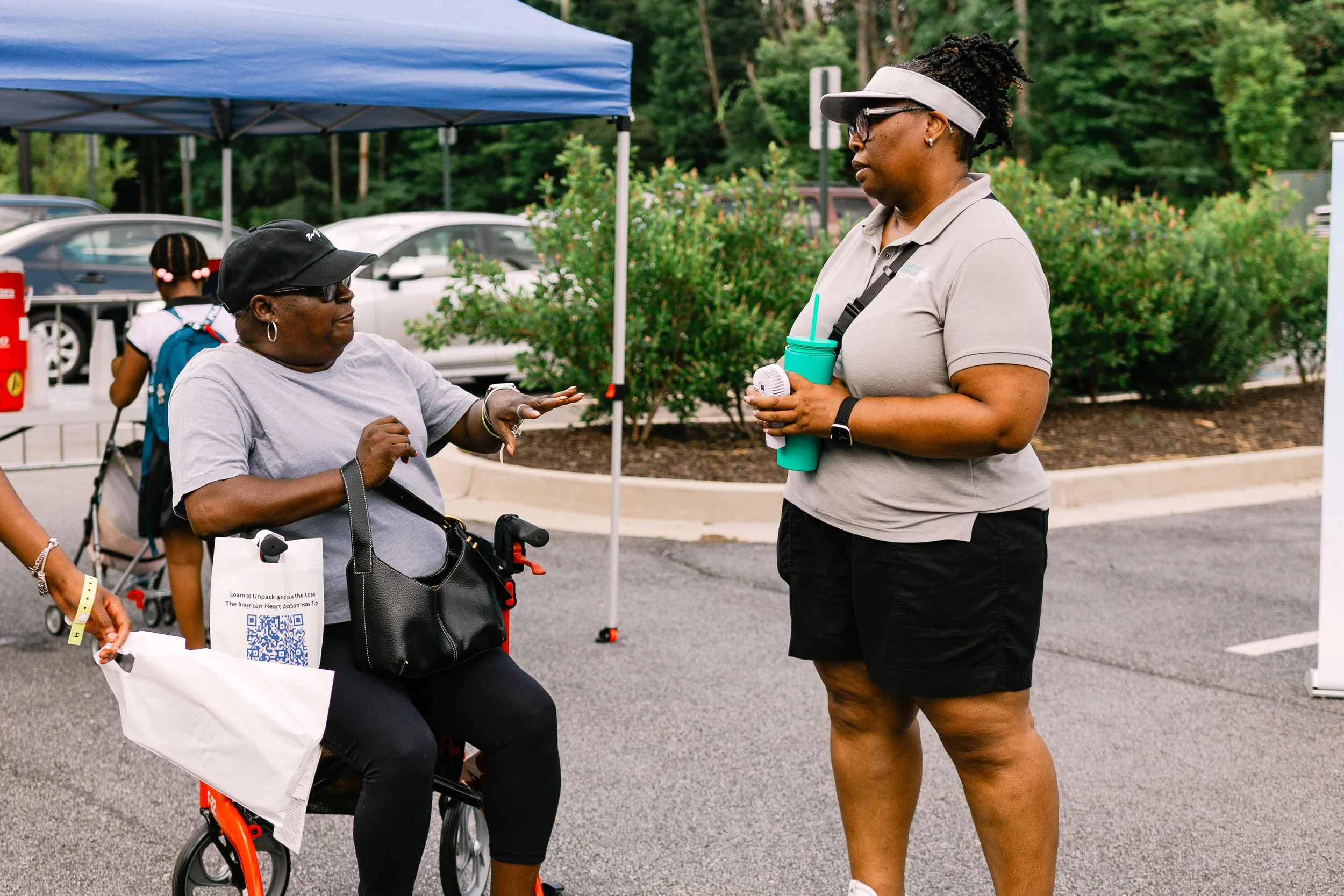 Commissioner Chakira Johnson speaks with an attendee using a mobility scooter during Chakira’s Cookout.