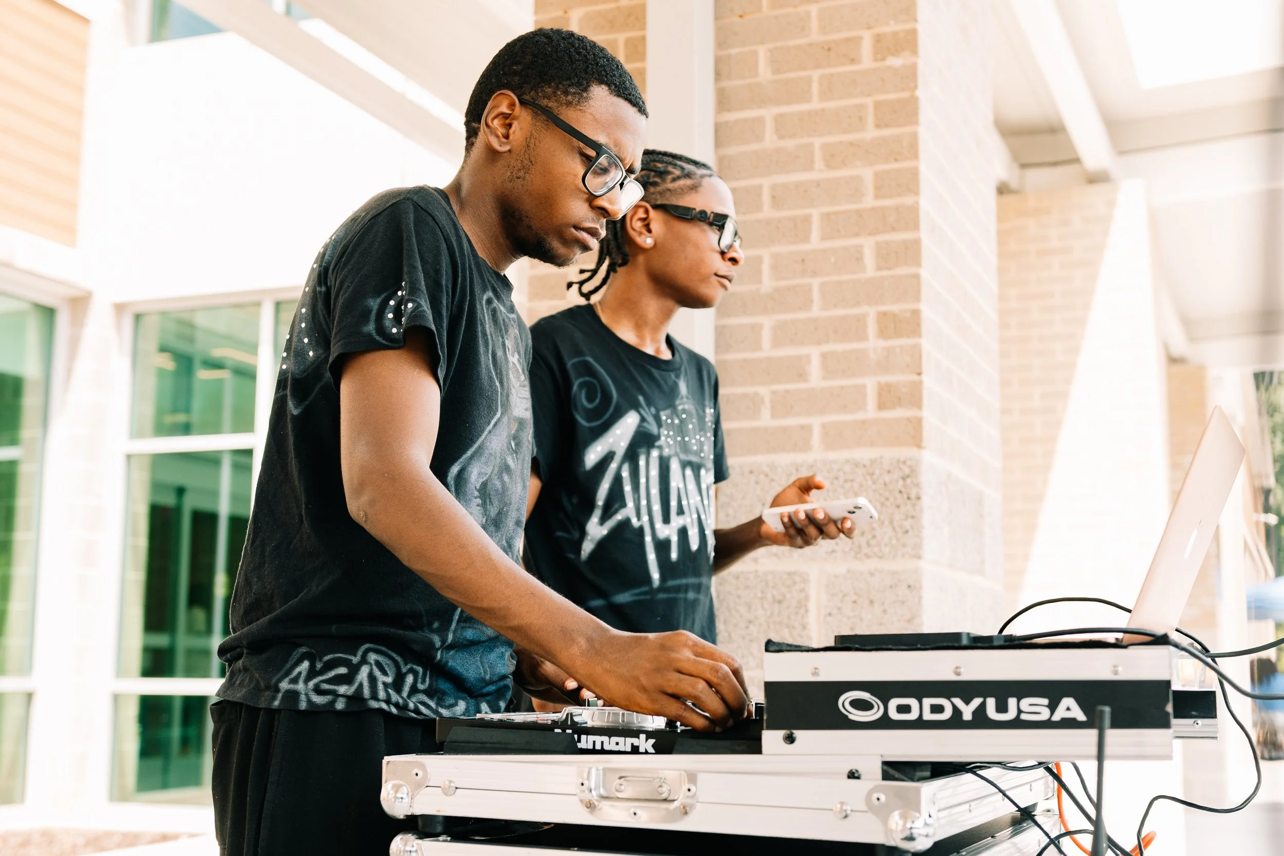 Two DJs manage music and sound equipment outside the East Central DeKalb Community & Senior Center during Chakira’s Cookout.