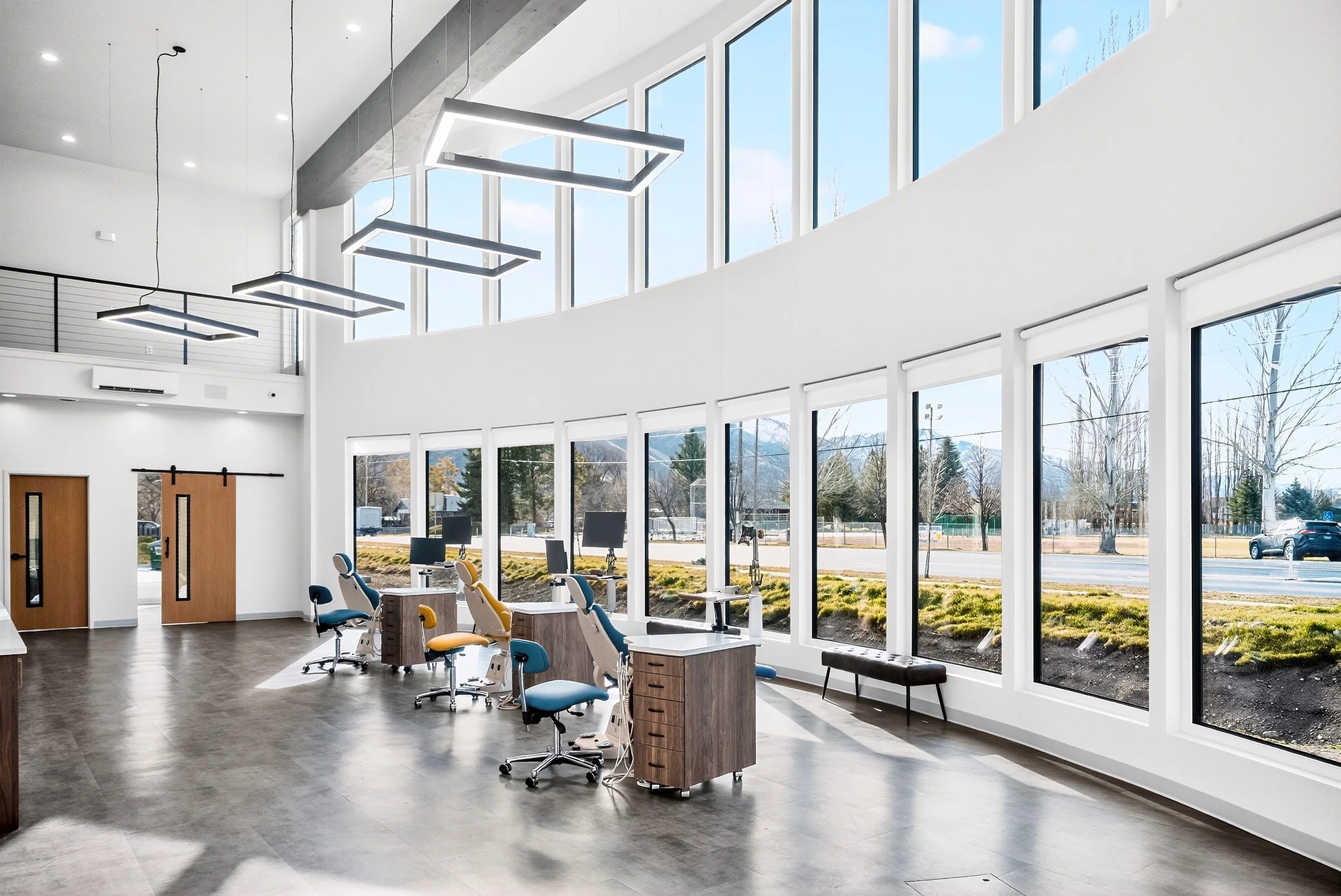 Bright modern orthodontic clinic with large windows, desks, and chairs