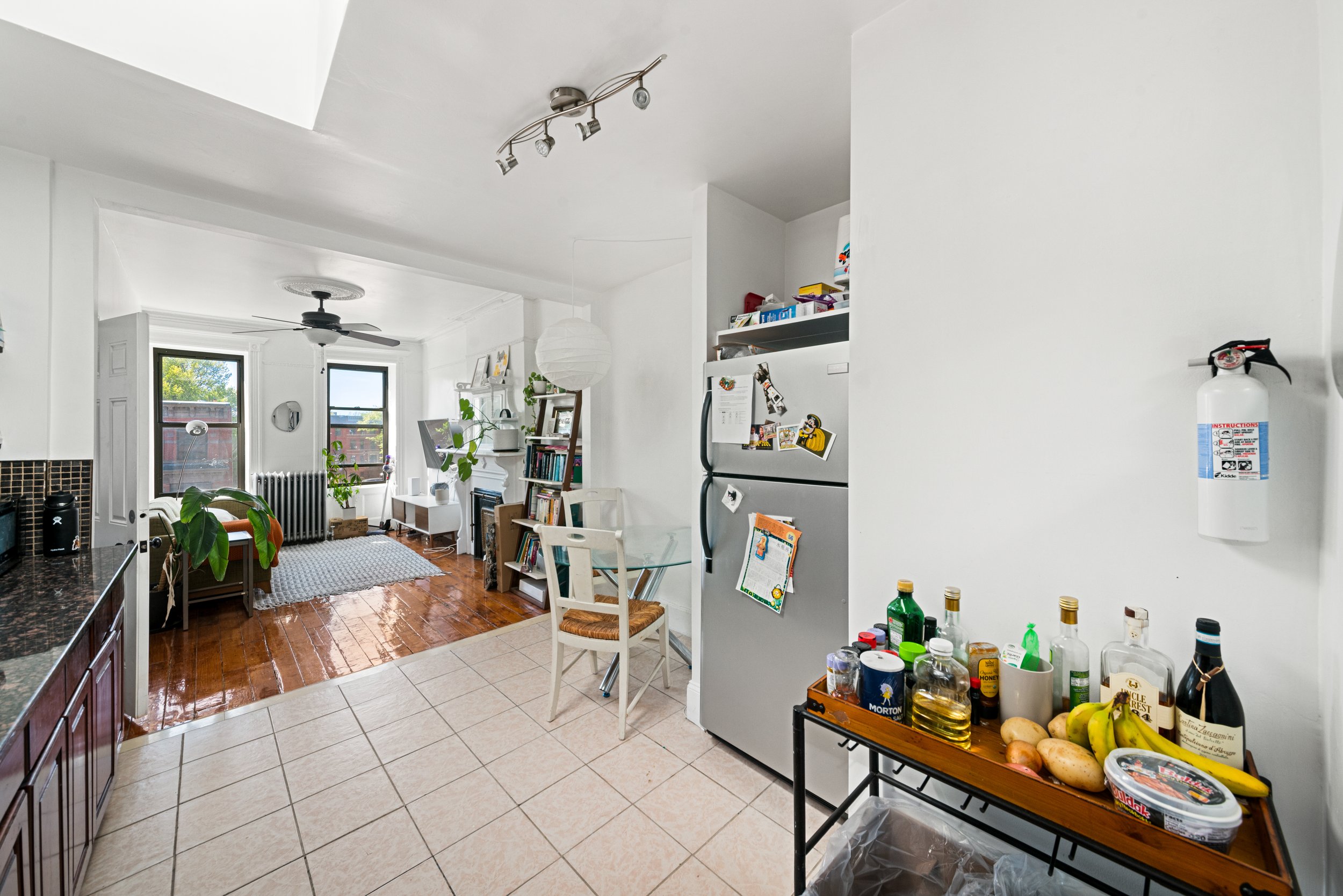 Brightly lit by skylight the eat in kitchen leads to the adjacent sunny living room. The tile gies way to the pristine wood floors of the living space.