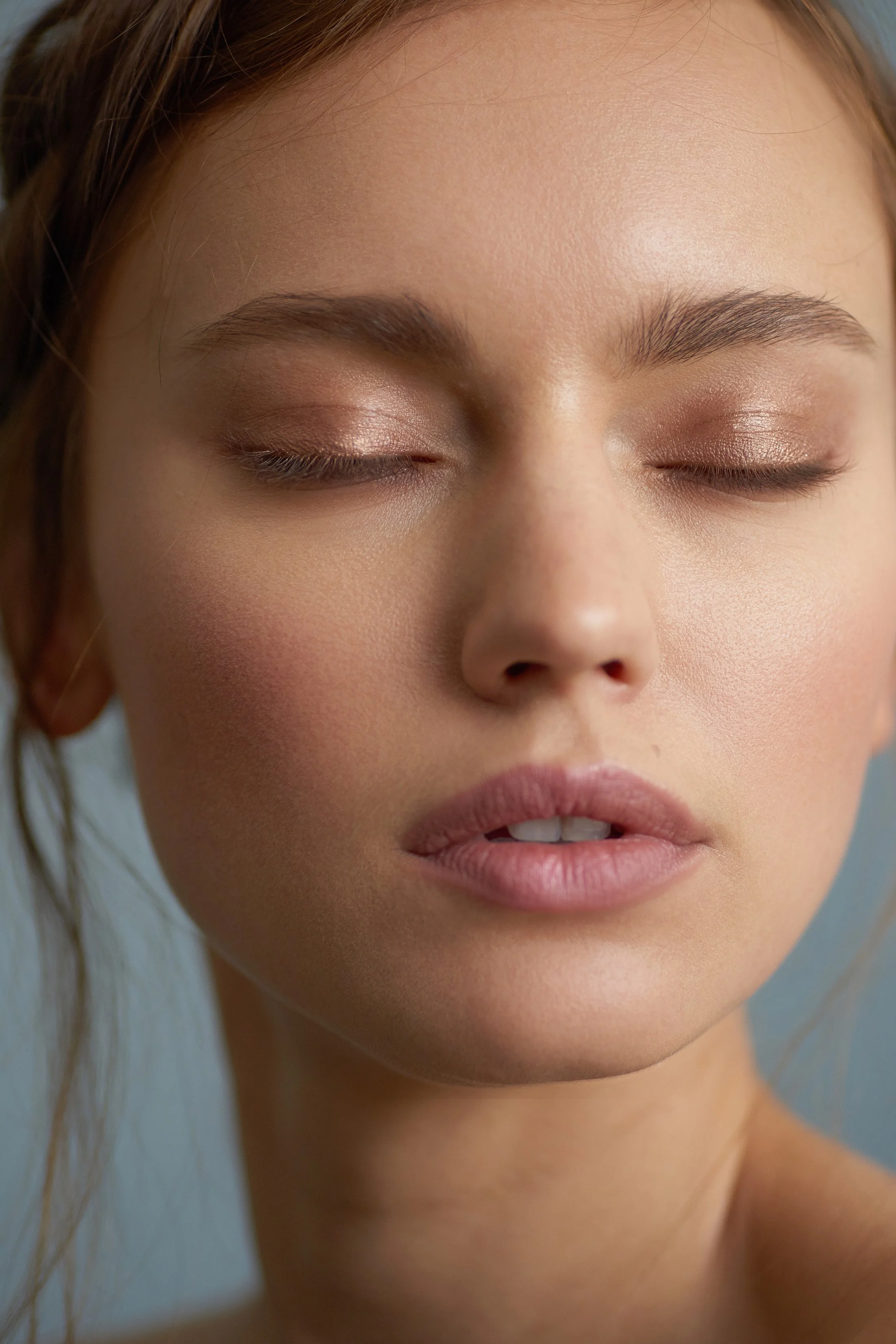Close-up beauty portrait featuring glowing skin and effortless hair by New York makeup artist and hairstylist