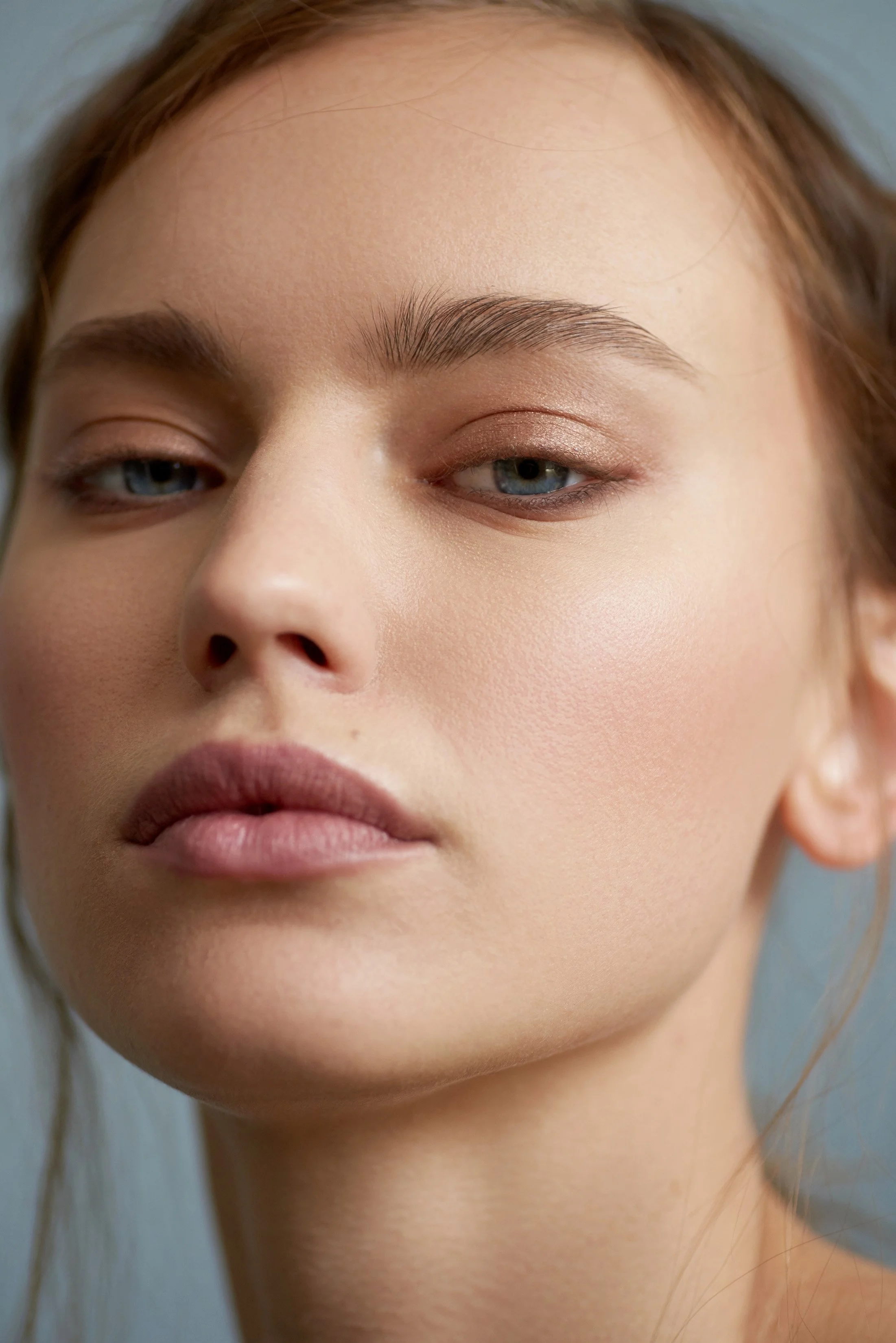 Close-up beauty portrait featuring glowing skin and effortless hair by New York makeup artist and hairstylist