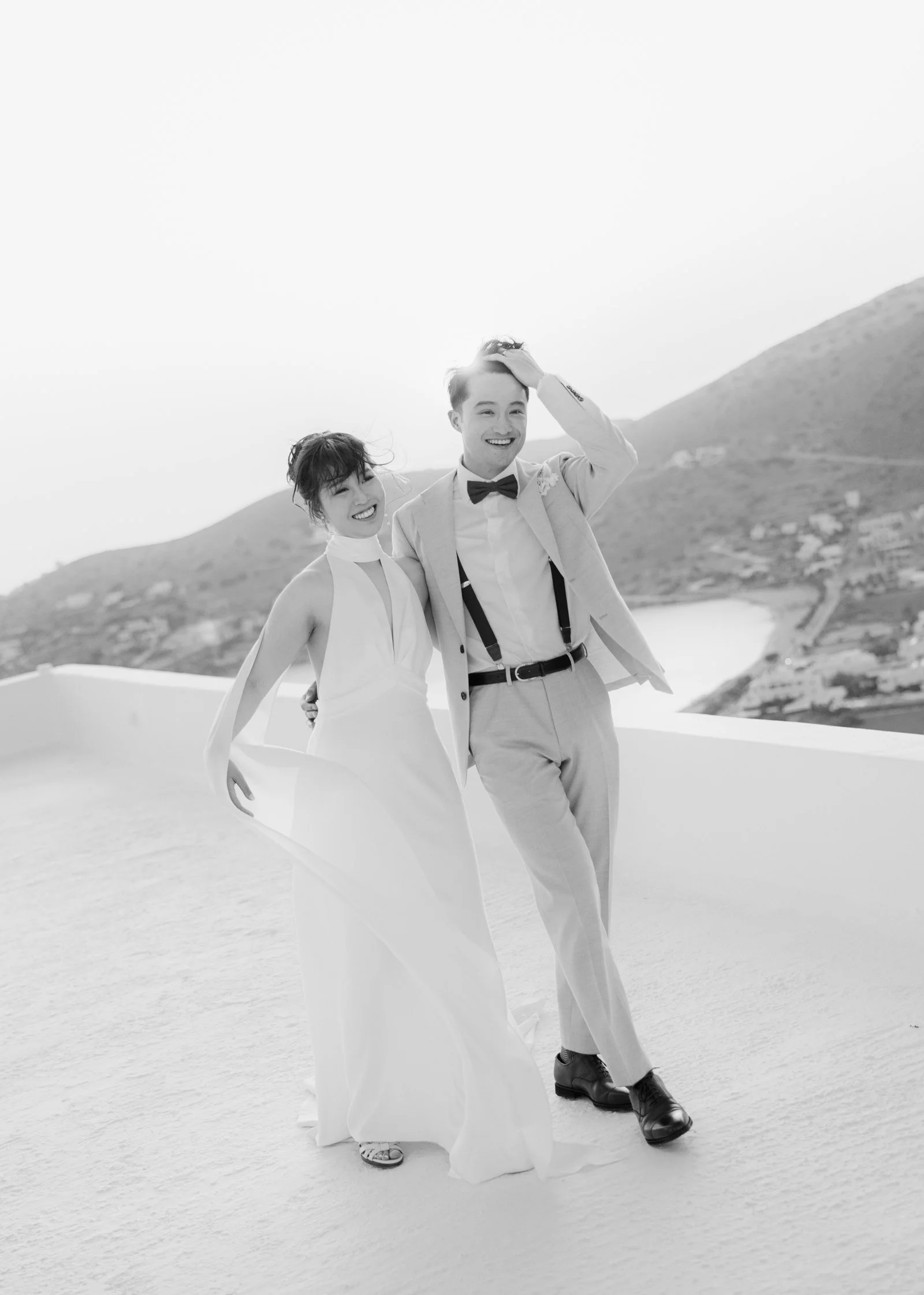 Bride and groom walking on a roof at sunset.