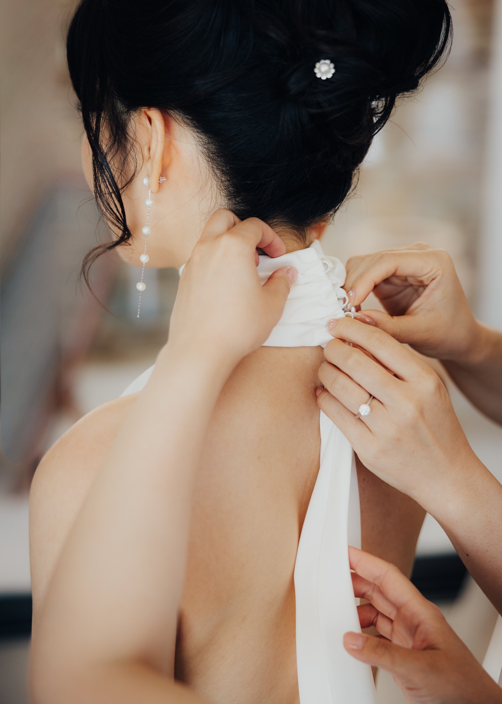 A bride getting help with putting on her dress.
