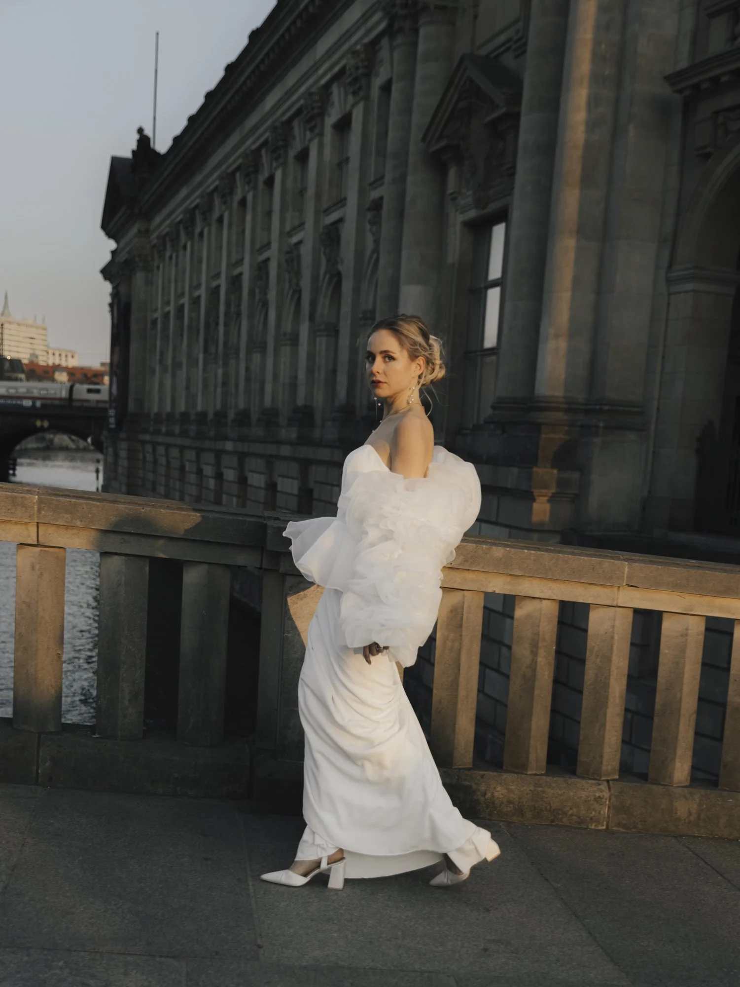 A cool fashion forward bride walking the streets of Berlin in sunset lighting