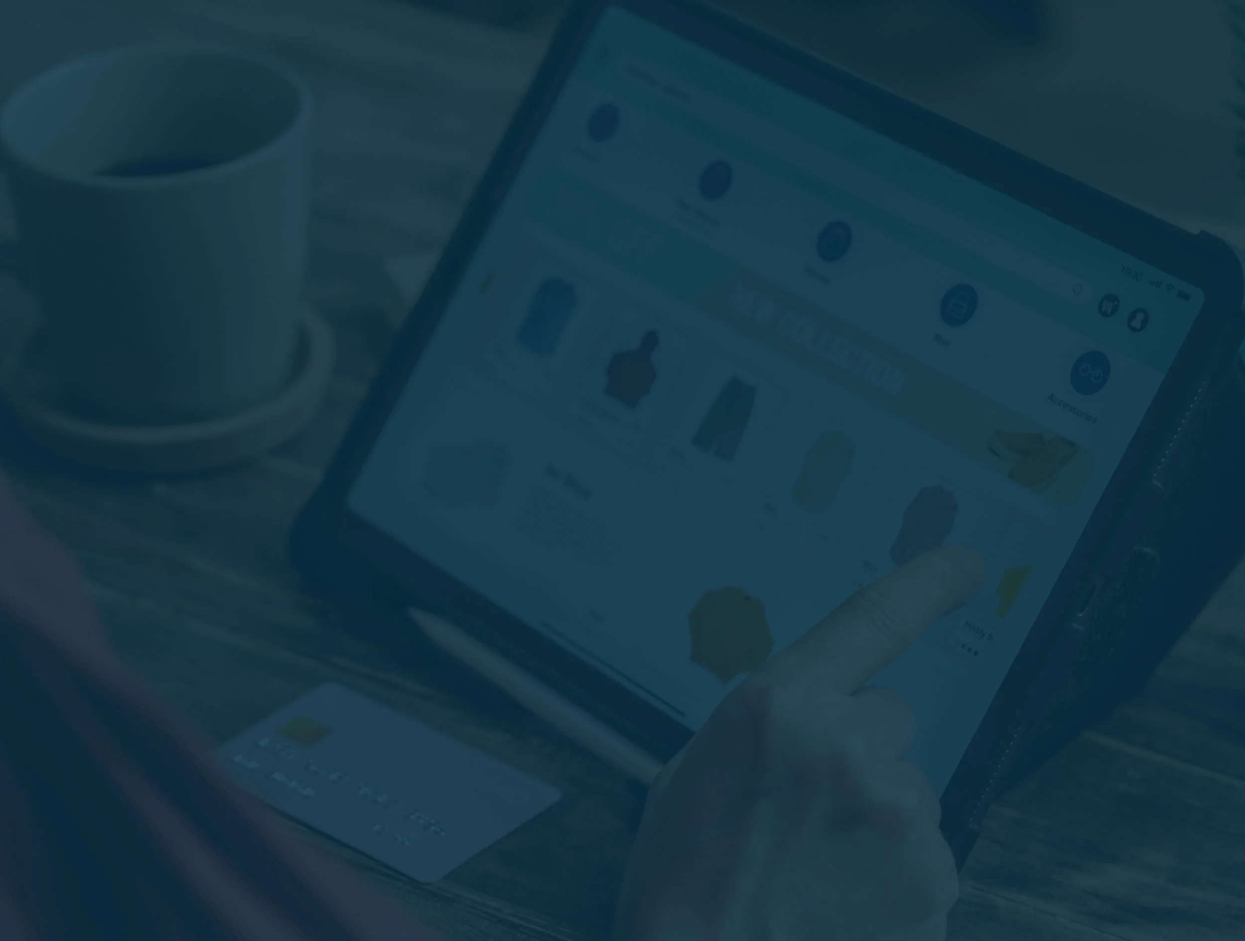 Person browsing an online marketplace on a tablet with a cup of coffee nearby.