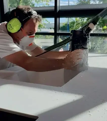 Artisan en train d’usiner un plan de travail dans l’atelier Oleksiak à Aubière, près de Clermont-Ferrand.