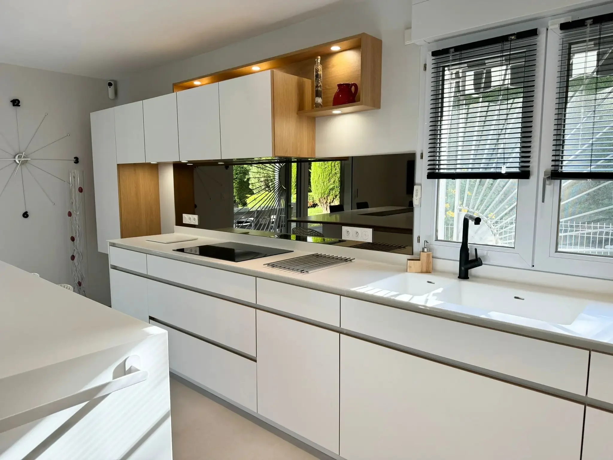 Cuisine blanche et bois au design moderne, avec plan de travail épuré et rangements sur mesure, réalisée par Oleksiak à Clermont-Ferrand.
