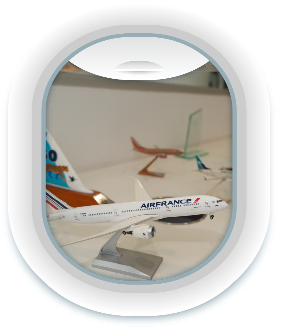 Modelo de avión de Air France sobre una mesa, con otros modelos de aviones y globos en el fondo.
