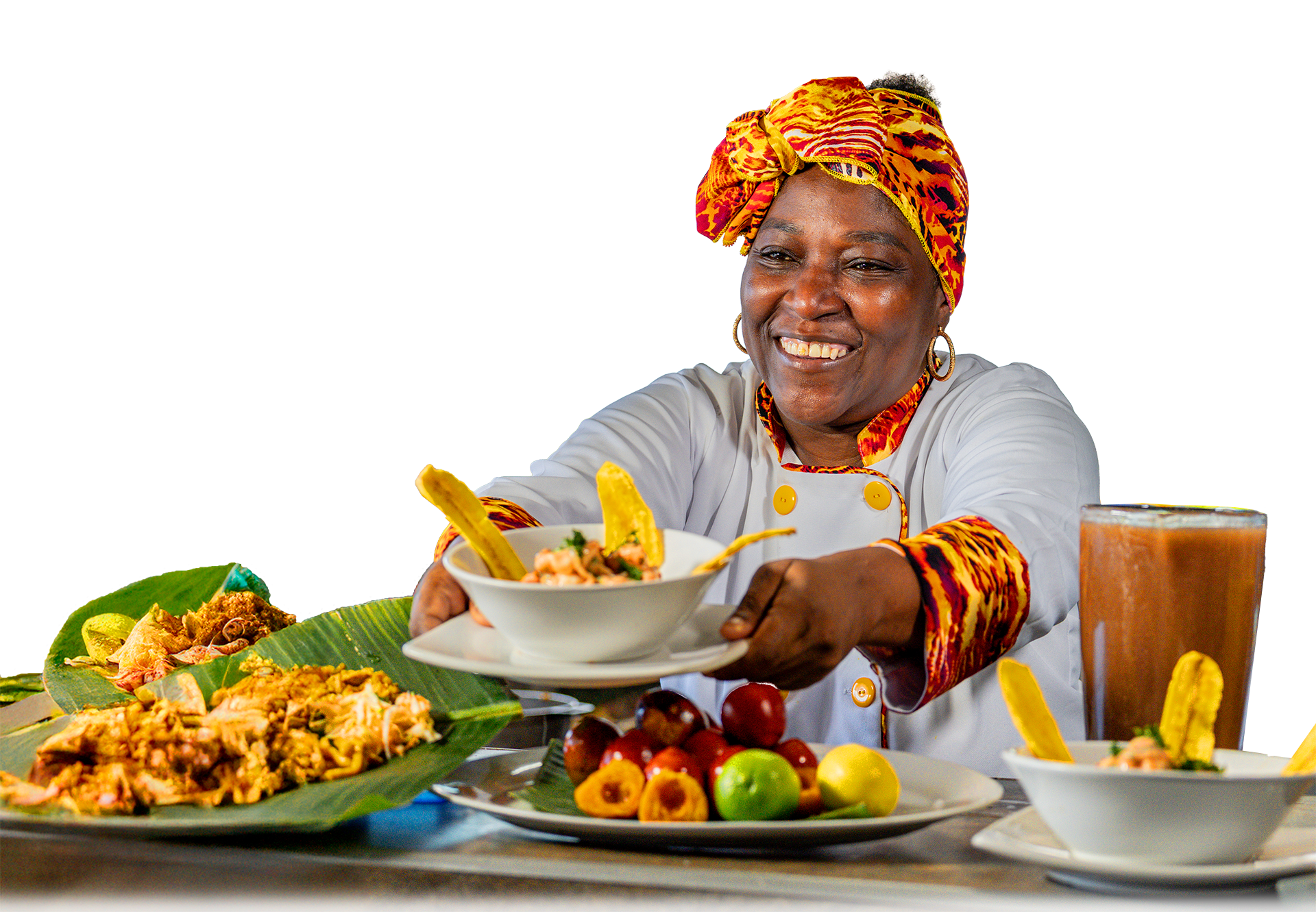 Mujer sonriente con un turbante colorido sirviendo comida en un evento con diversas opciones de platos típicos.