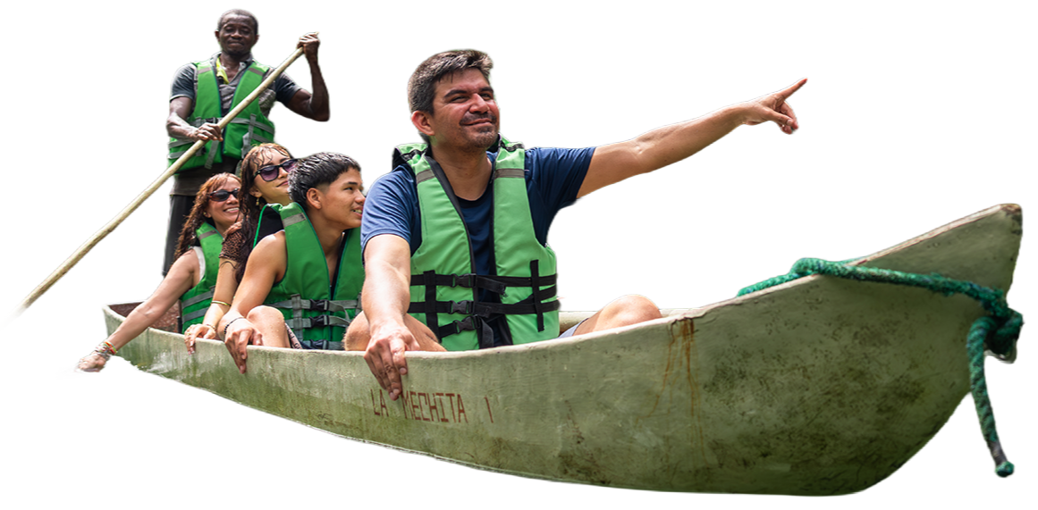 Grupo de seis personas en una balsa, con chalecos salvavidas, navegando por un río, señalando hacia adelante, con un guía en la parte trasera usando un remo.