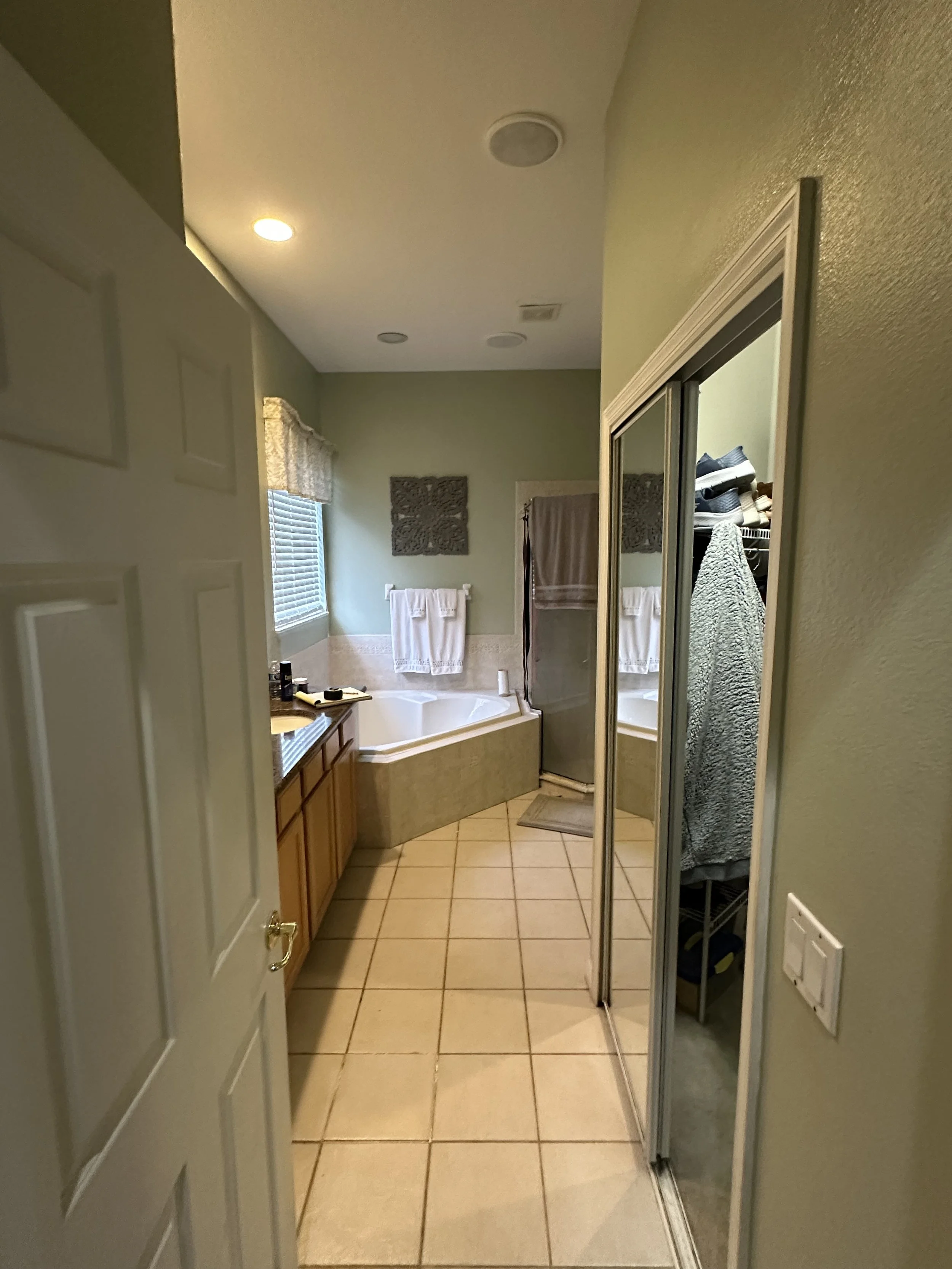Original primary bathroom before remodel with maple cabinets, brown granite, a corner garden tub, and a neo-angle shower in Lake Mary.