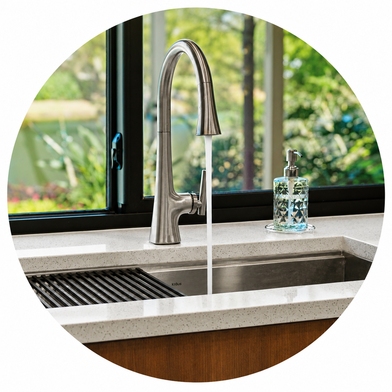 Kitchen sink with a modern stainless steel faucet, a soap dispenser, and a large window showing a lush outdoor scene.
