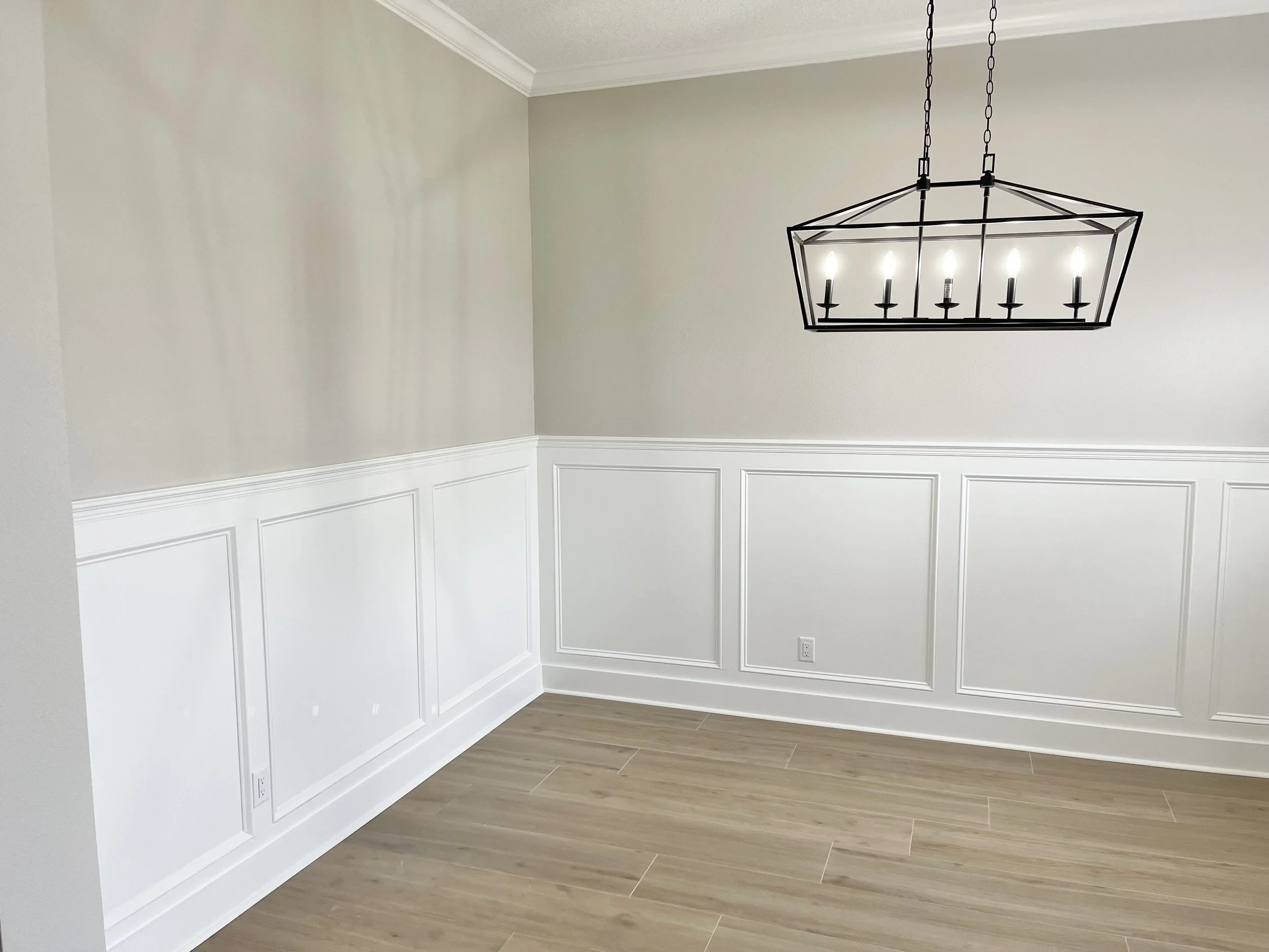 Whole home remodel in Rock Springs Ridge Apopka with custom wainscoting trim, new flooring, and full paint with pendant chandelier.