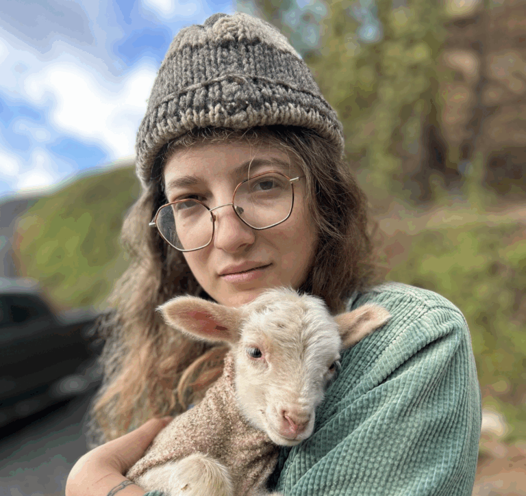 Nica Rabinowitz Fiberhouse Collective and Fibershed smiling  with long hair and glasses outdoors