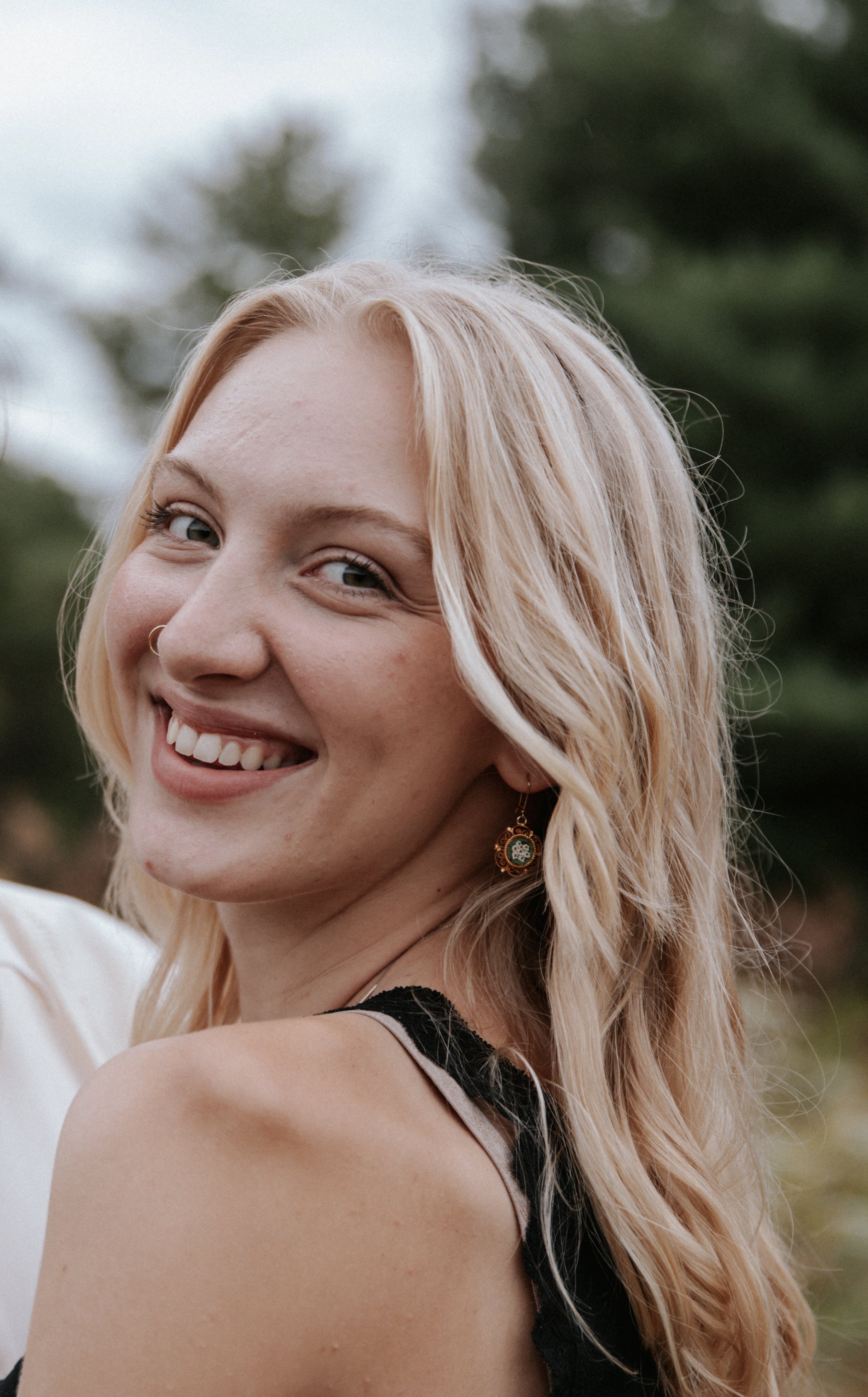 Woman with blonde hair smiling outdoors