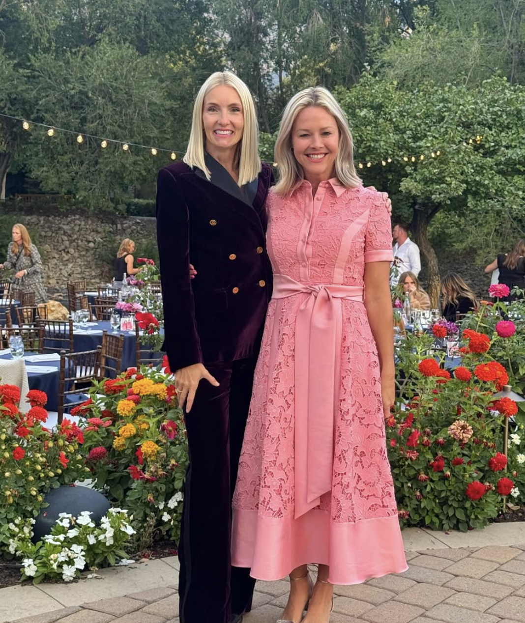 kristin and emily bell mccormick stand together in a garden