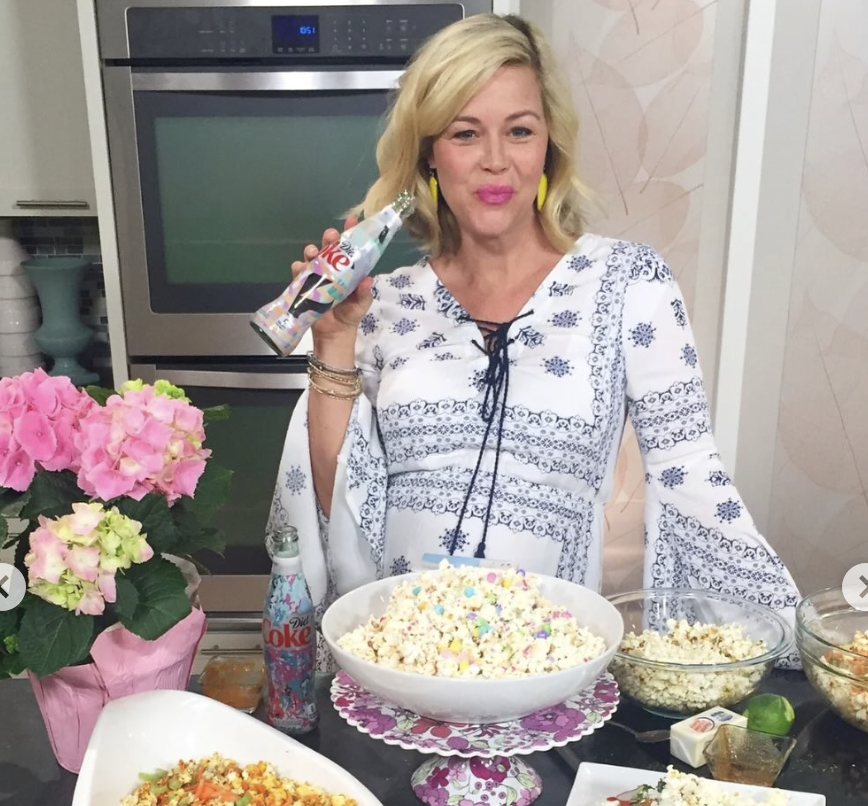 Kristin poses with Diet Coke on her cooking show in front of popcorn