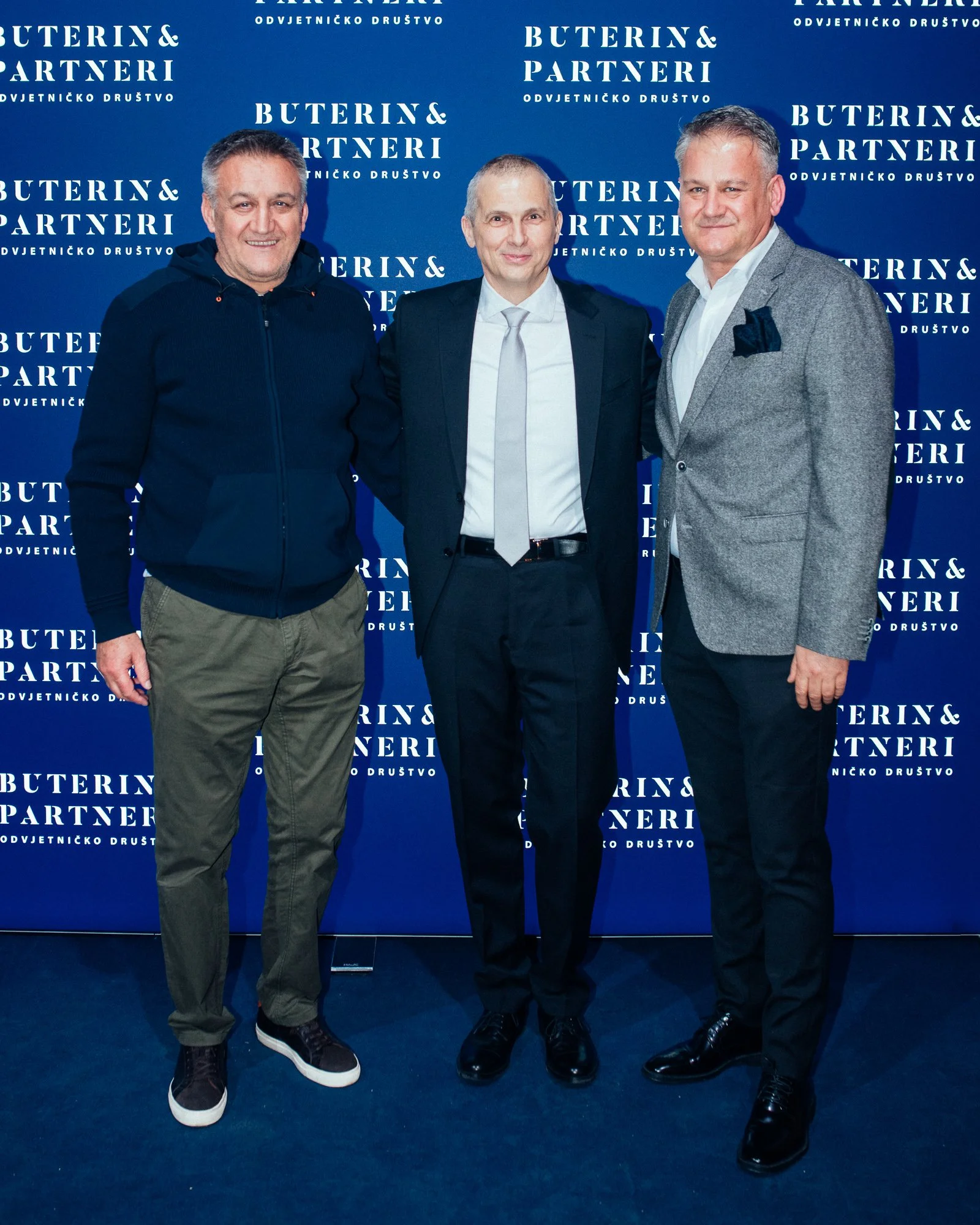 Three men standing in front of a blue backdrop with white text that reads "BUTERIN & PARTNERI.