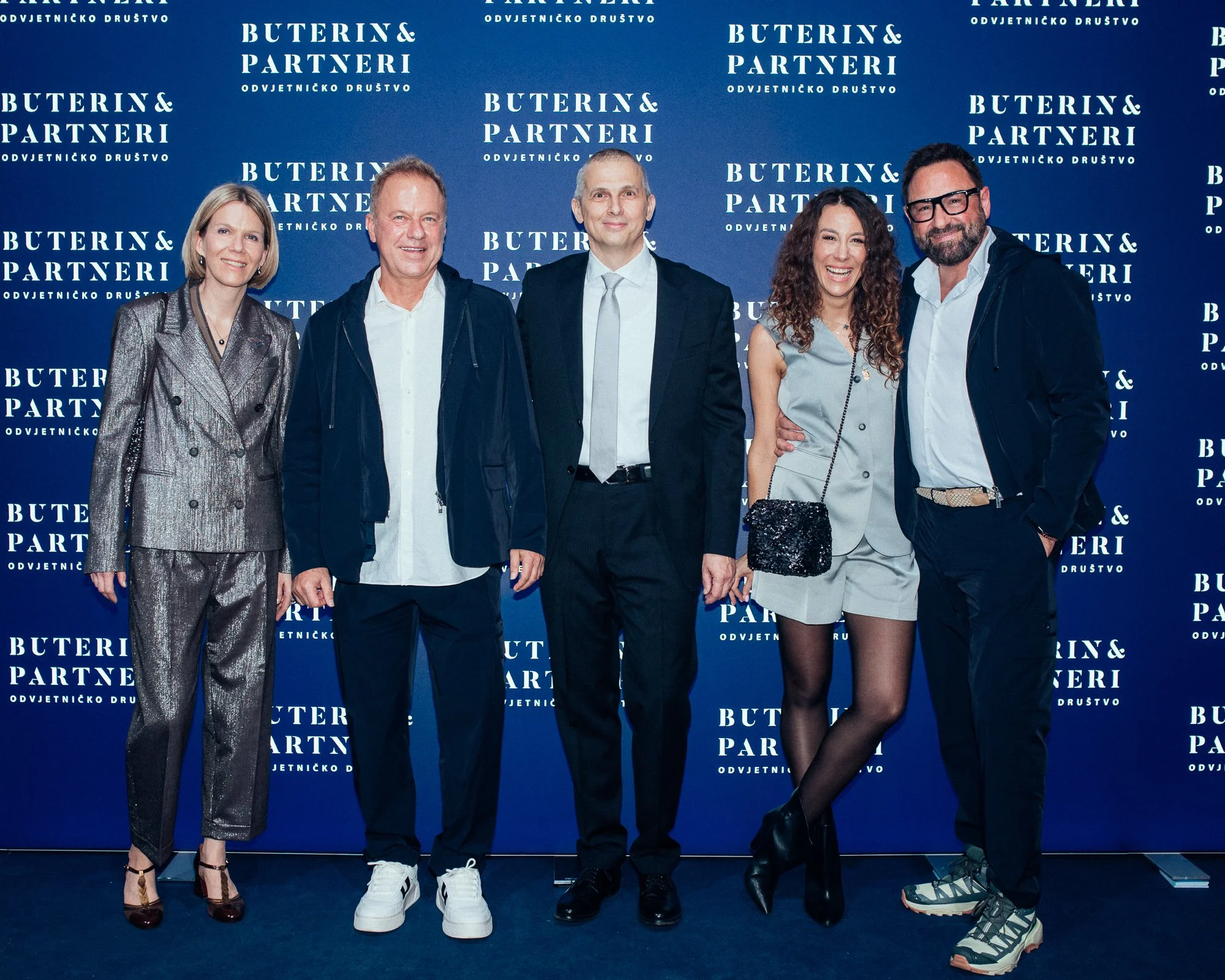 Group of five people standing in front of a blue backdrop with white text that reads 'Buterin & Partneri Odvjetničko Društvo.'