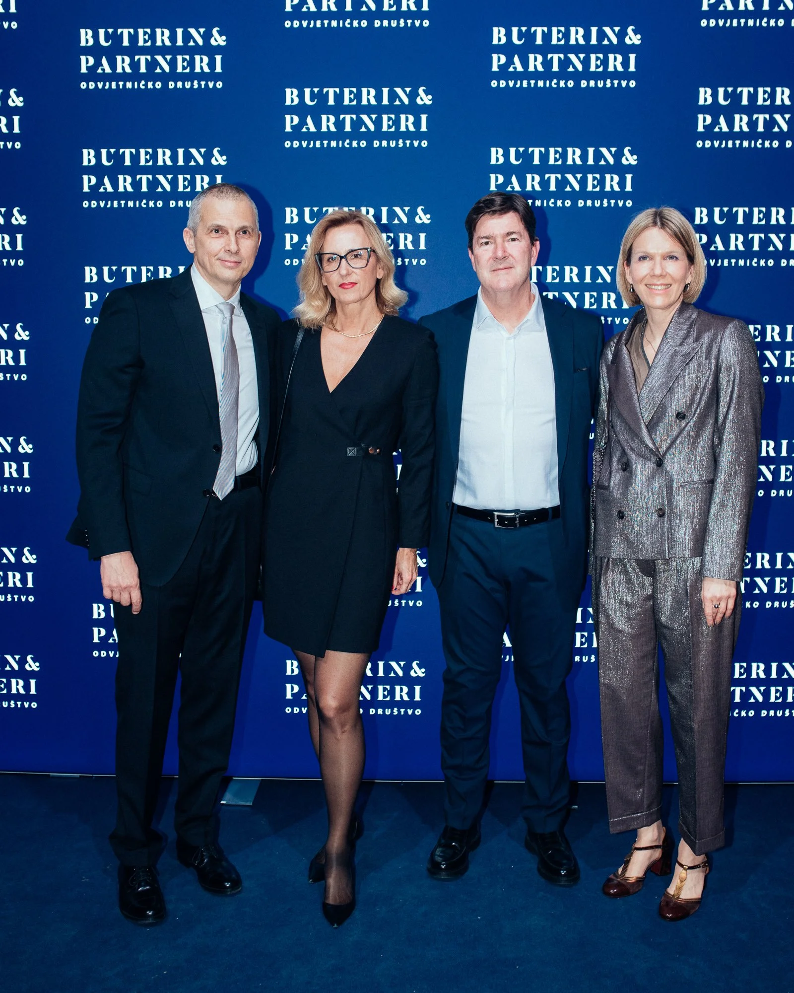 Four professionally dressed individuals standing in front of a blue backdrop with white text that reads "Buterin & Partneri" and "Odvjetničko društvo," indicating a formal or corporate event.