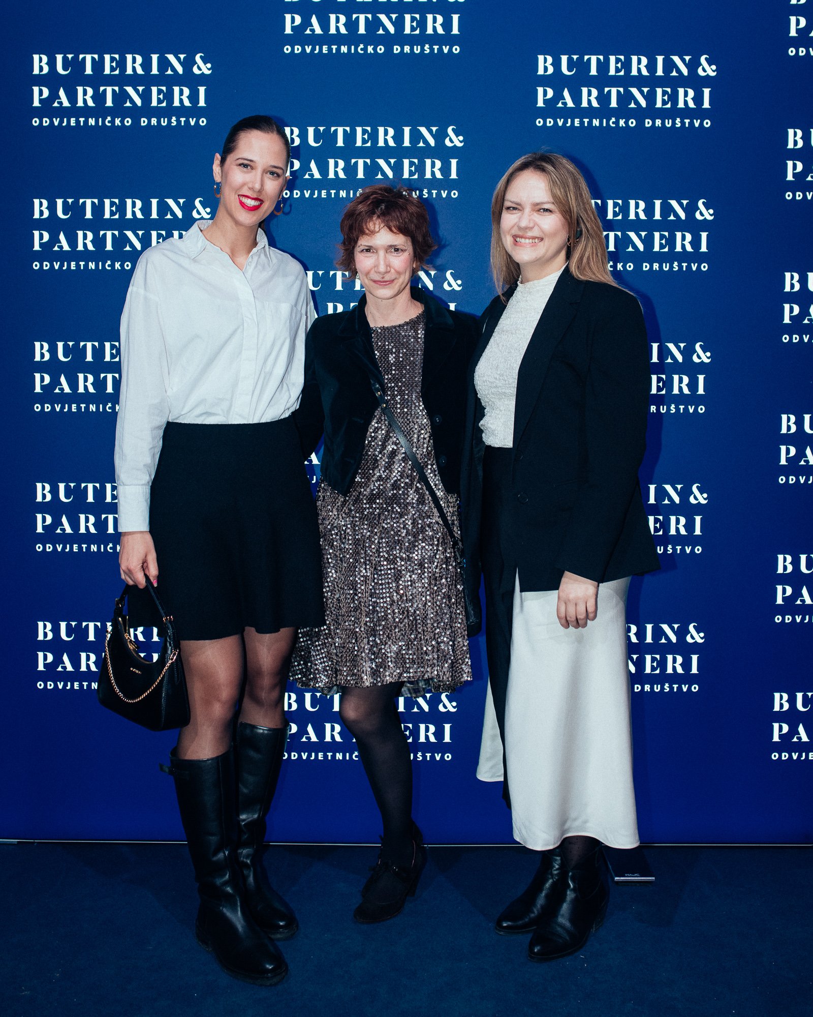 Three women standing in front of a blue background with white text that reads 'BUTERIN & PARTNERI ODVJETNIČKO DRUŠTVO'.