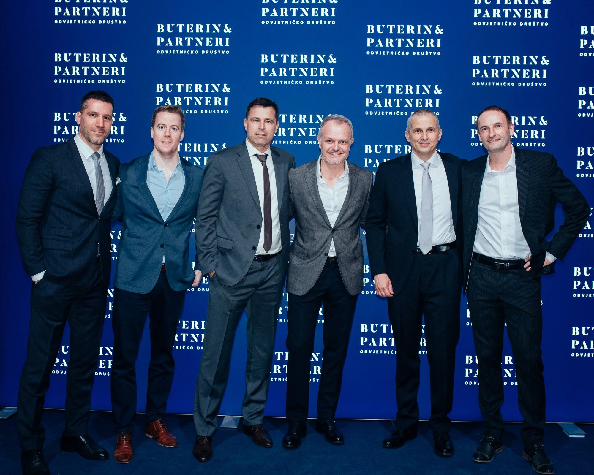 Six men in business suits standing together against a blue background with white text that reads 'BUTERIN & PARTNERI'.