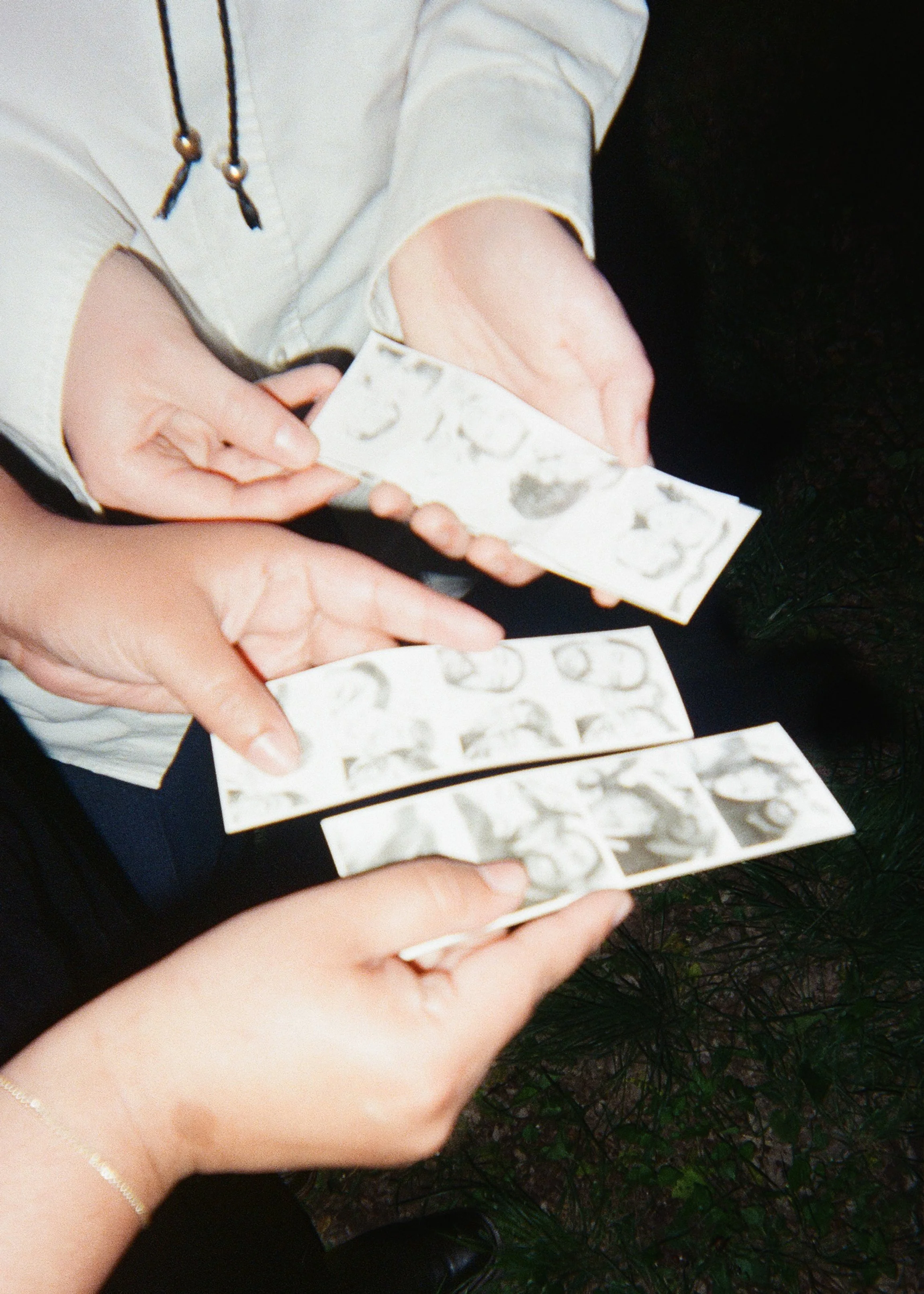 Two people holding photo strips of black and white photobooth photographs at a wedding in Austin, TX.