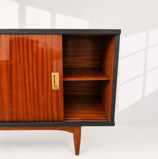 💛💛💛 Mid-Century Modern sideboard in rosewood veneer, featuring three drawers, sliding doors, and tapered legs. Professionally restored, with the entire frame refinished in black to enhance its clean lines and the natural contrast of the wood grain