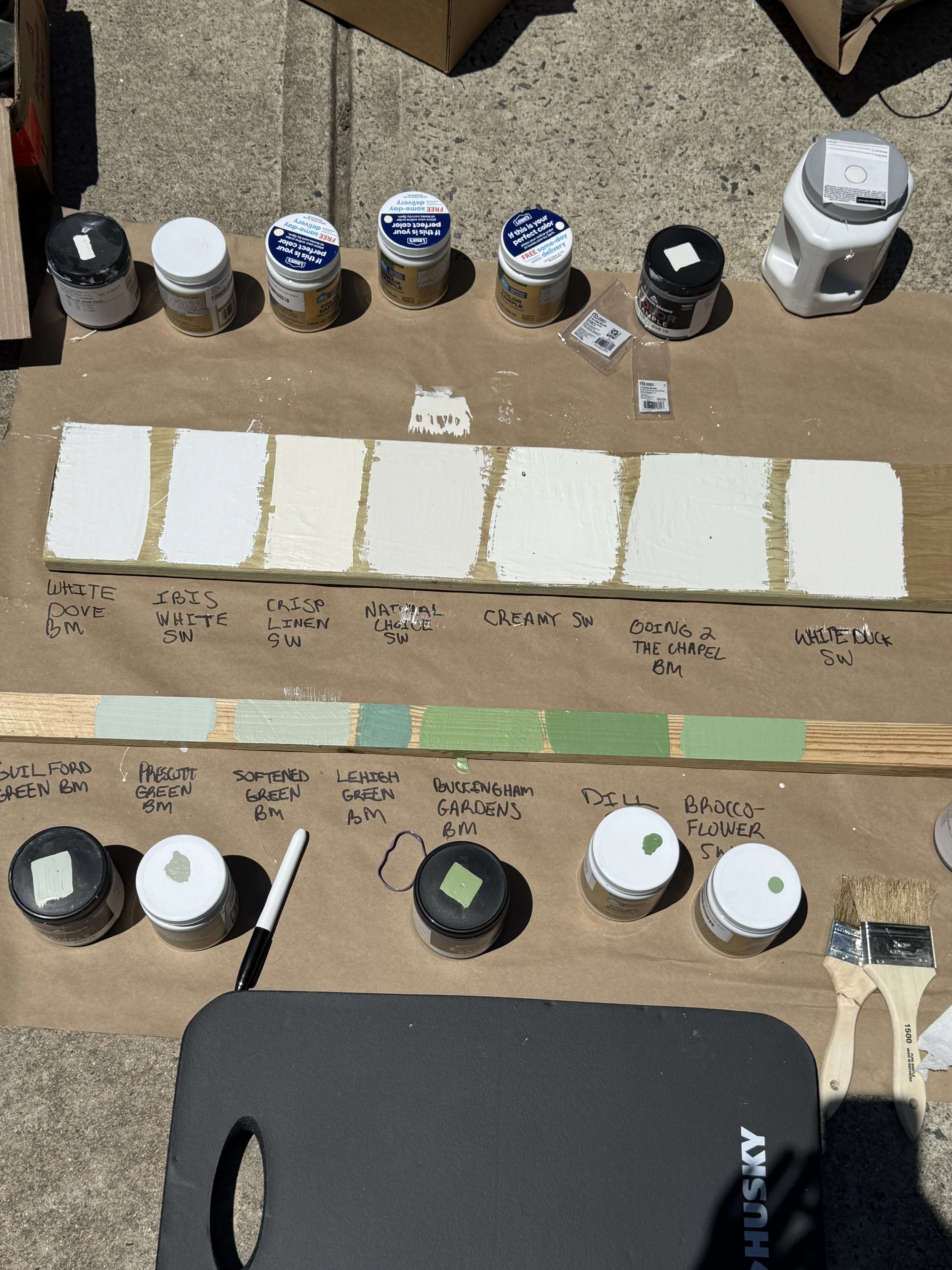 Several shades of white and green paint are visible on two pieces of scrap wood.