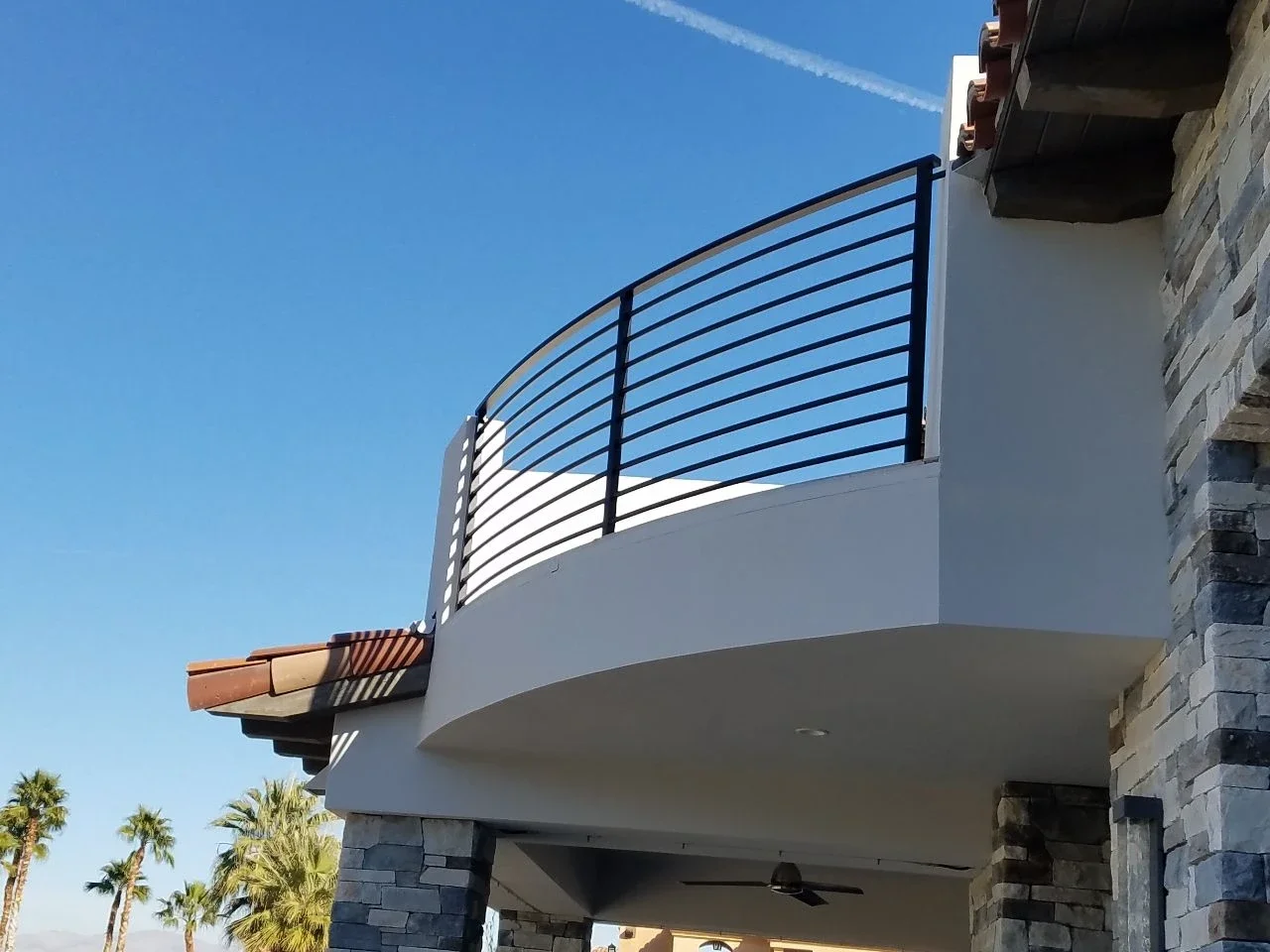 black, curved balcony railing with horizontal steel bars and three vertical steel bars