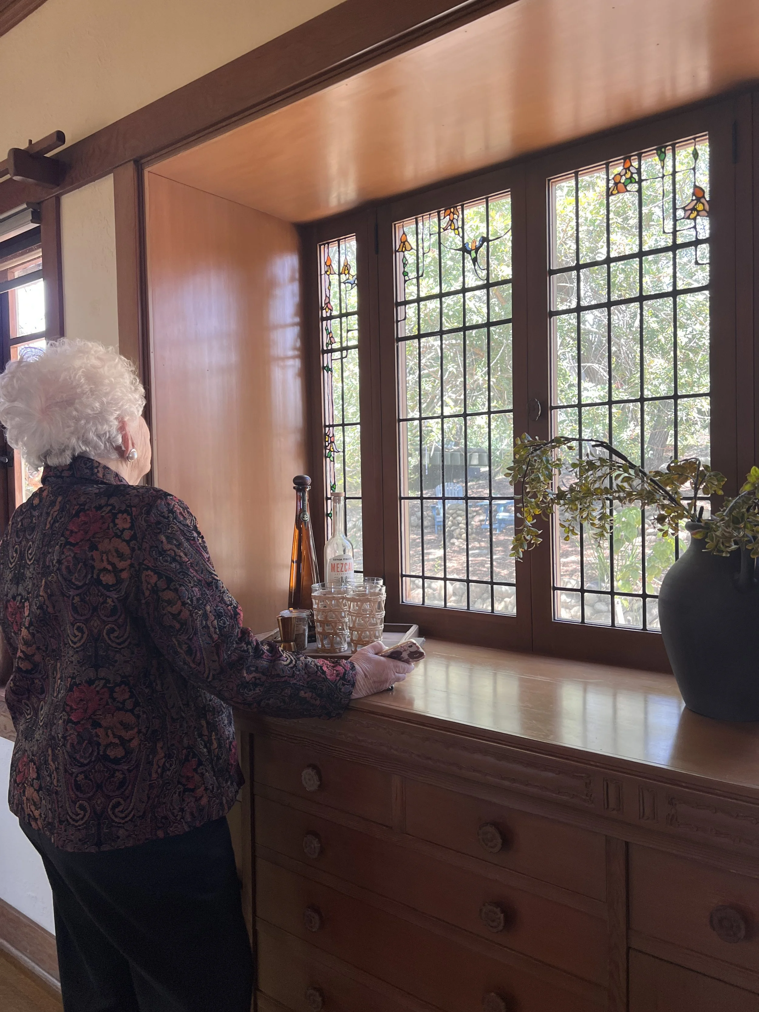 Virginia Hales, granddaughter of architect Henry Mather Greene, examines the art glass designed by her grandfather.