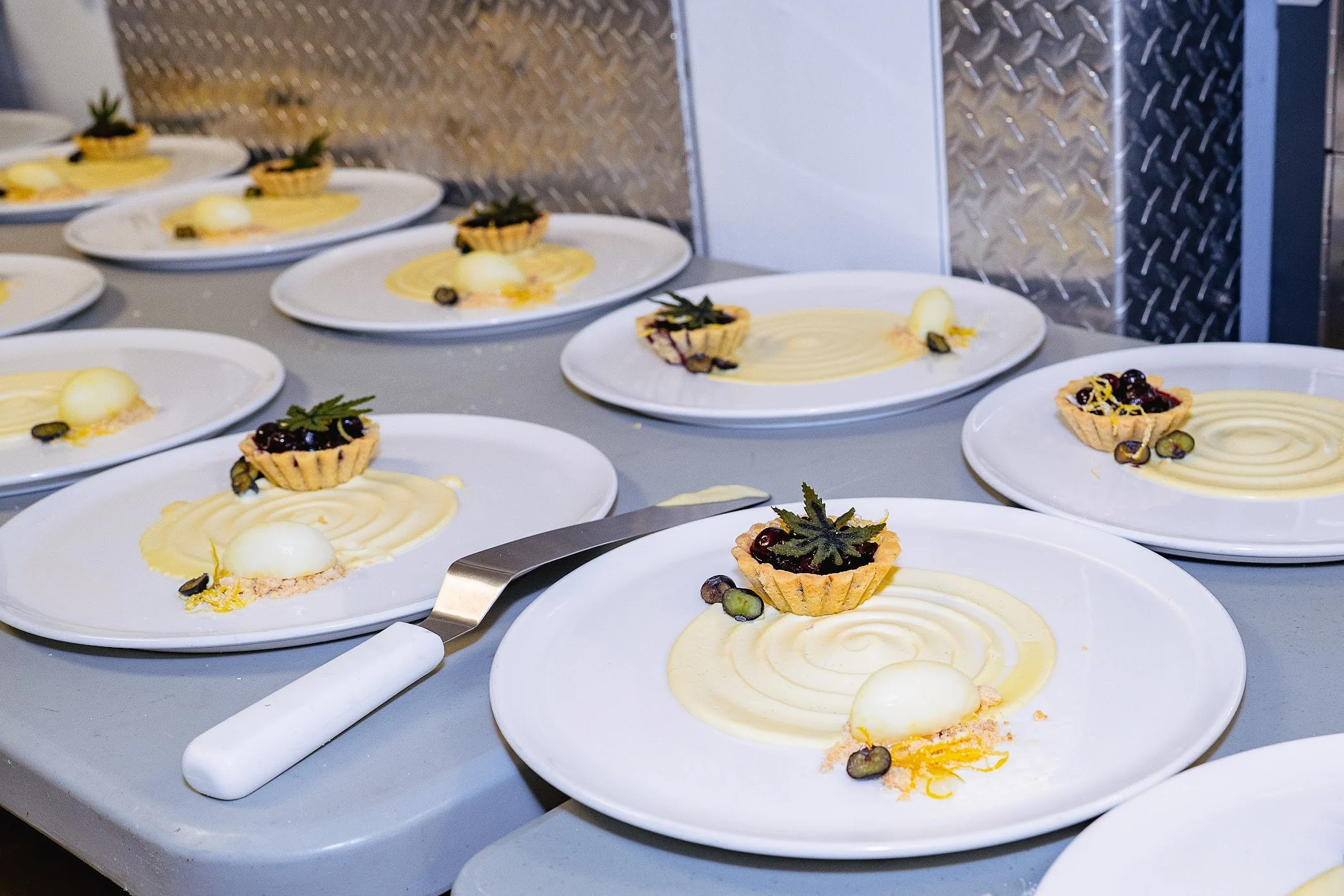 Multiple plates with lemon tart desserts, arranged on a kitchen counter.