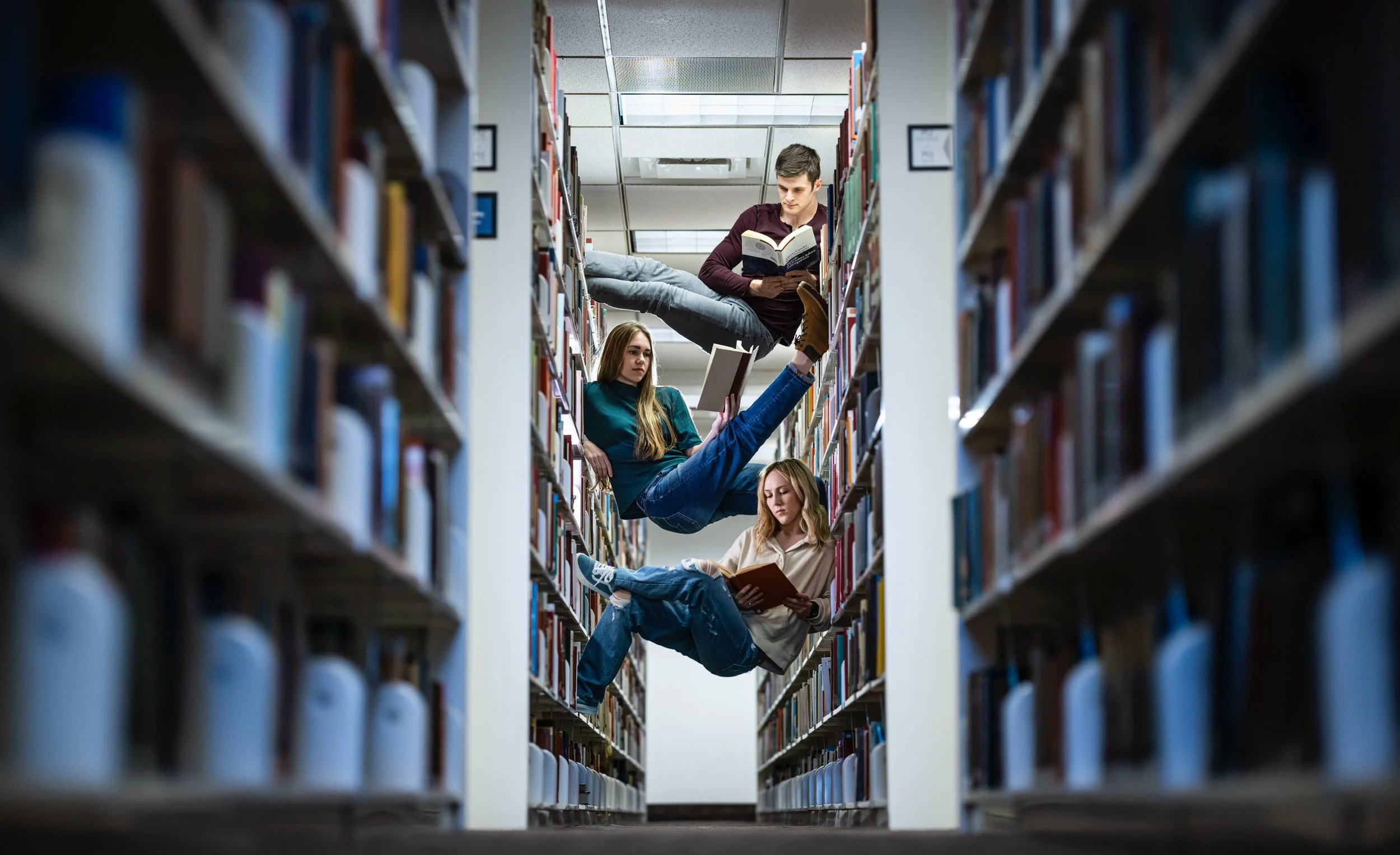 Logan Barnes, Dee Dee Smith, and another BYU Dance major student reading in the BYU Library. This picture was taken in 2022 in a library showcasing dance on Brigham Young University campus.