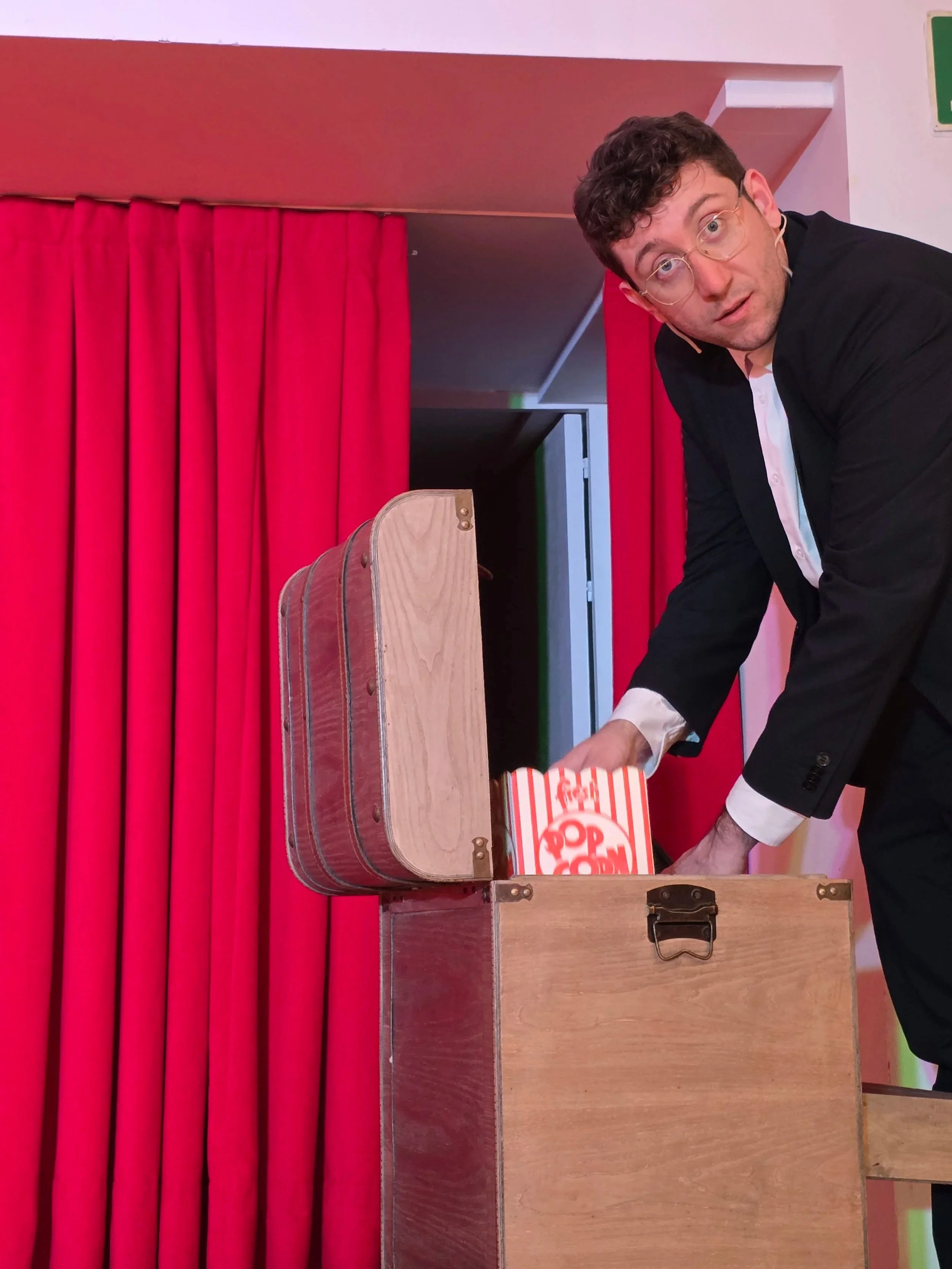 Primo piano di Mago Cofano durante uno spettacolo di magia comica, con espressione teatrale e coinvolgimento del pubblico