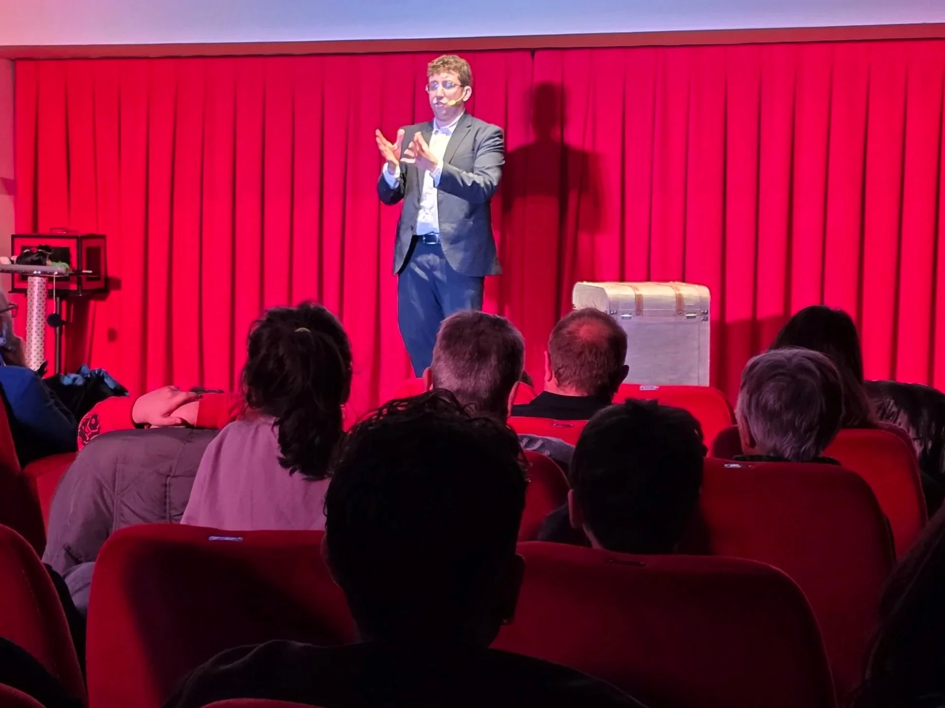 Spettacolo teatrale di magia comica con Mago Cofano sul palco, tra illusionismo, comicità e linguaggio cabarettistico.