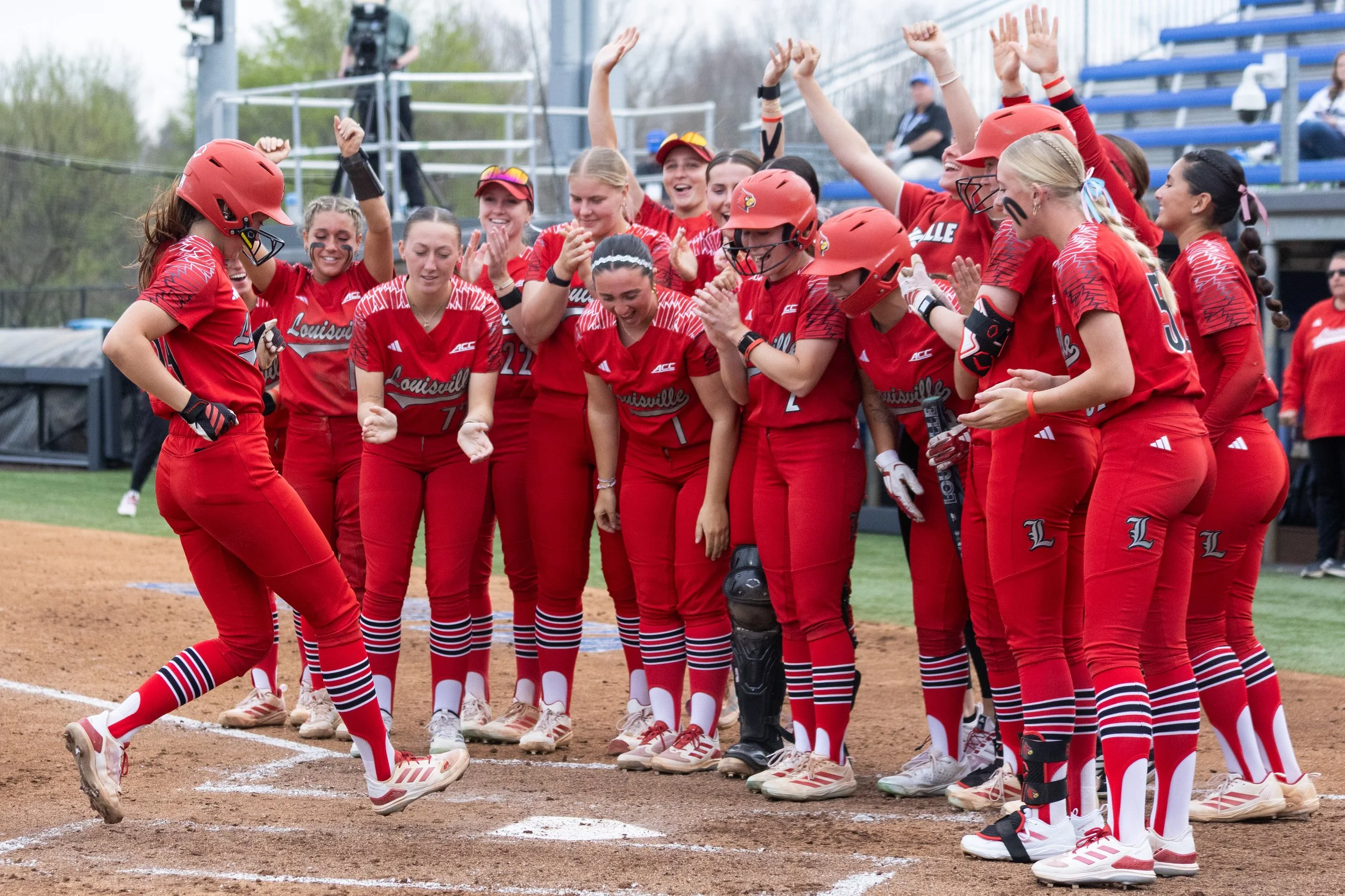 Softball team in red uniforms celebrating on the field