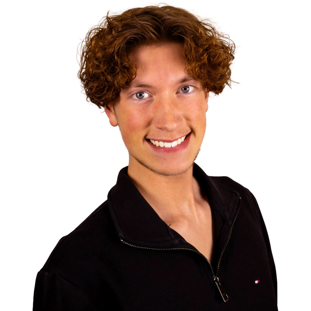 Young person with curly red hair, blue eyes, and light skin, smiling and wearing a black zippered shirt.