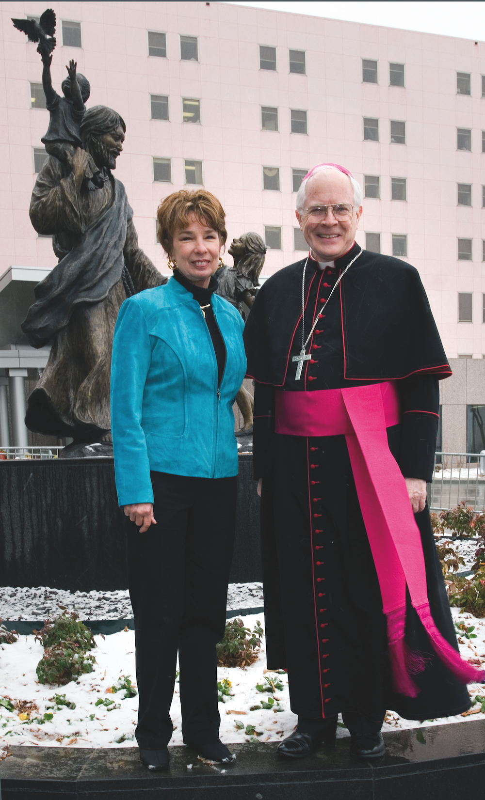 Rosalind Cook and Bishop Edward J. Slattery shown at St. Francis Children's Hospital dedication of "Christ's Love for the Children'' sculpture (visible in background).