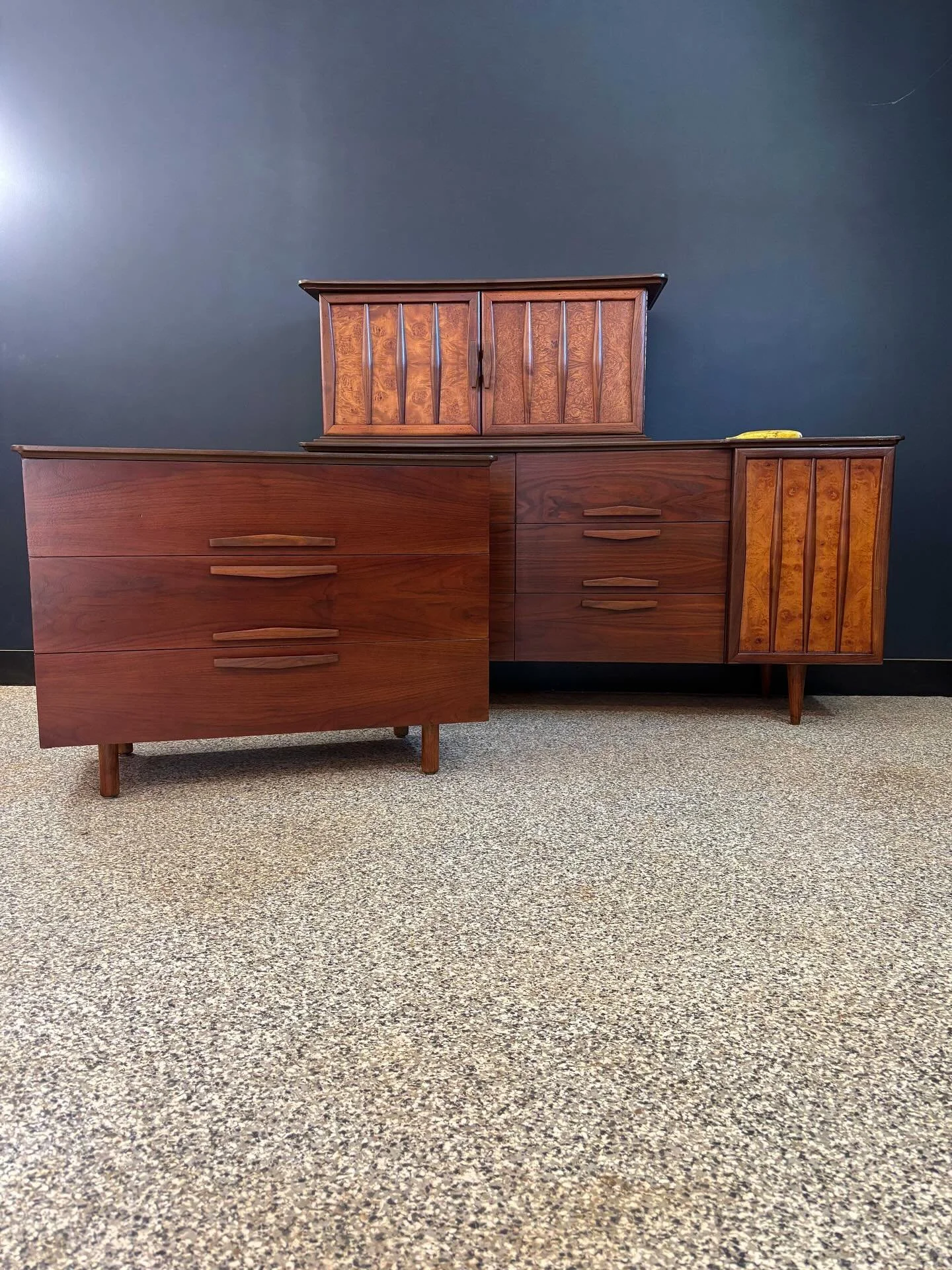 Restored vintage 1960&rsquo;s Mid Century Modern walnut and burlwood nine drawer triple dresser and two piece gentlemen&rsquo;s chest. Unmarked. ⁣
⁣
Chest topper has a slide out open shelf and open cubby. It was originally screwed onto the three draw