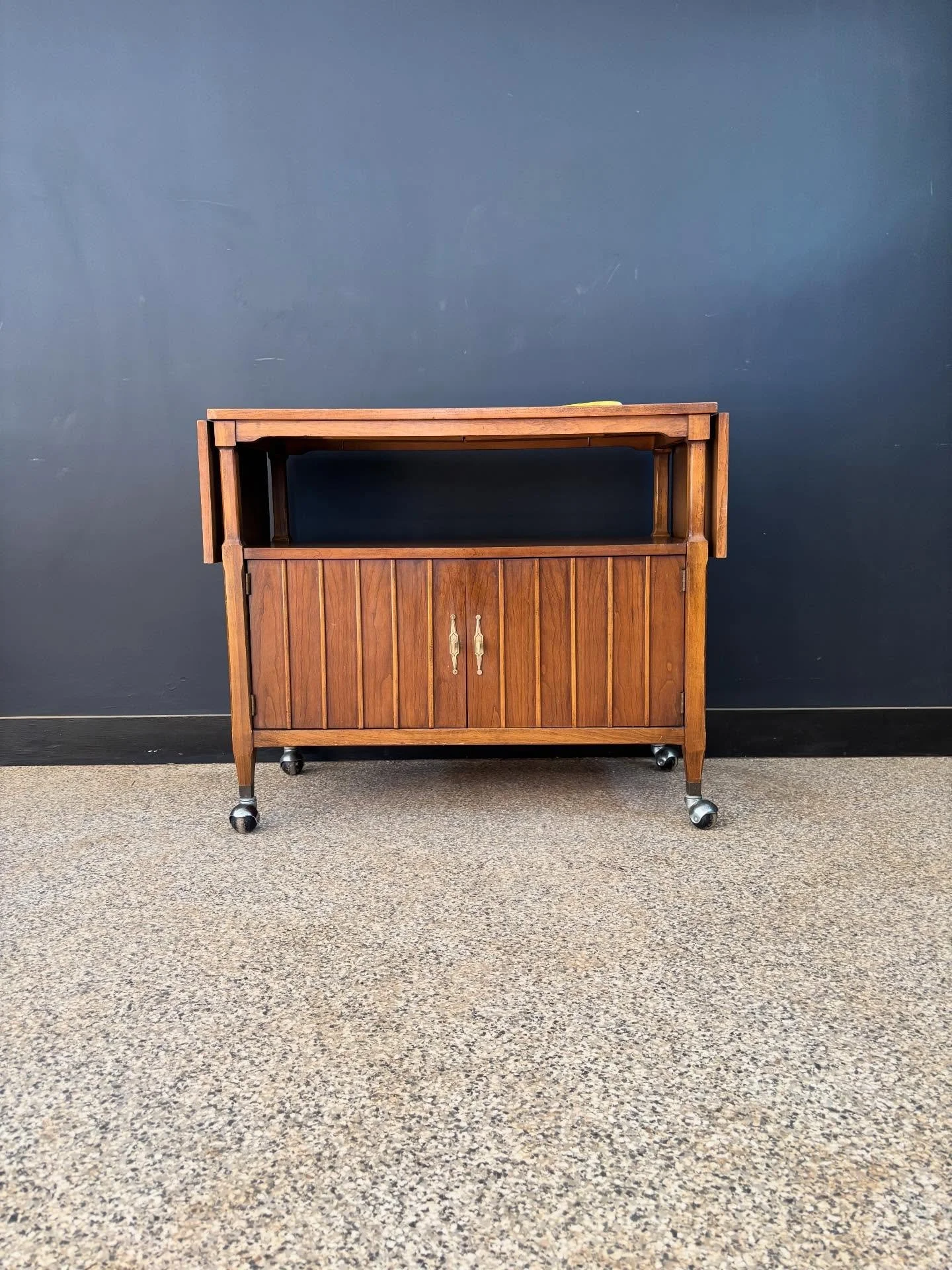 Vintage late 1960&rsquo;s Mid Century Modern walnut rolling bar cart cabinet. Unmarked. ⁣
⁣
Cute, solid, finished back, lots of storage, and all wheel drive casters. Formica top so you can mix your drinks in peace. ⁣
⁣
Banana for scale. ⁣
⁣
37.5 W x 