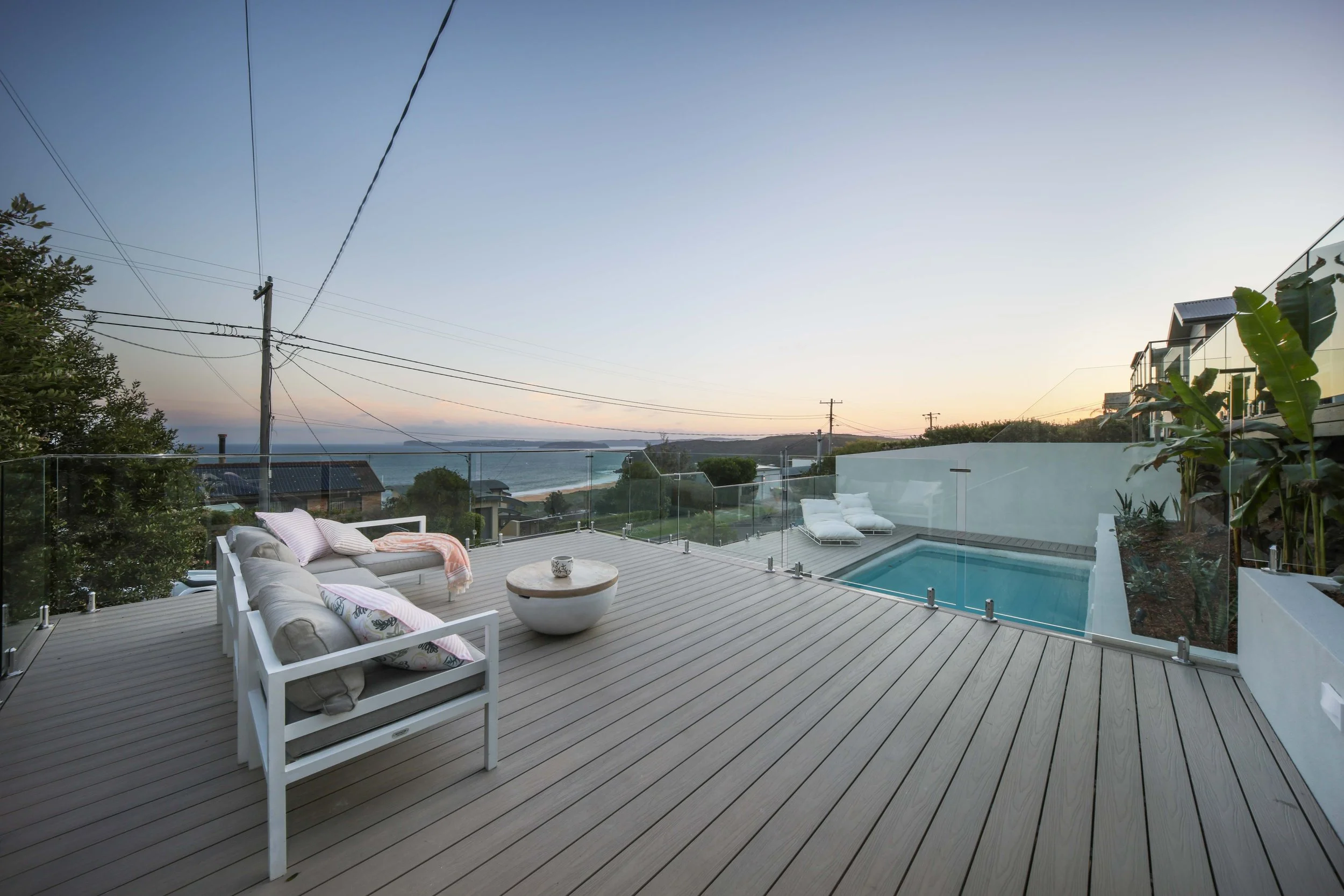 Expansive, deck, pool and view of beach and sky at dusk
