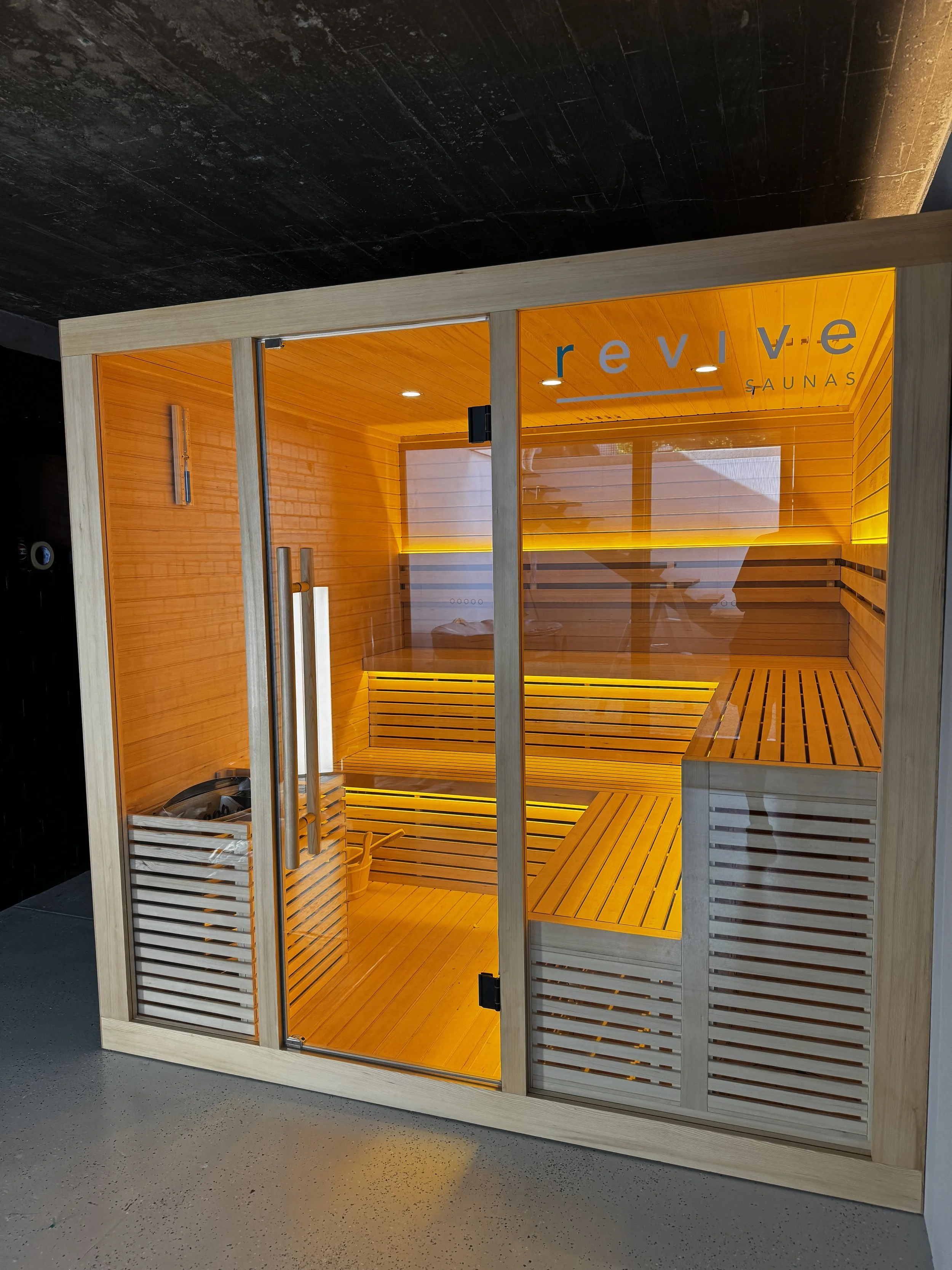 Traditional home sauna Perth setup in a modern wooden room with glass door