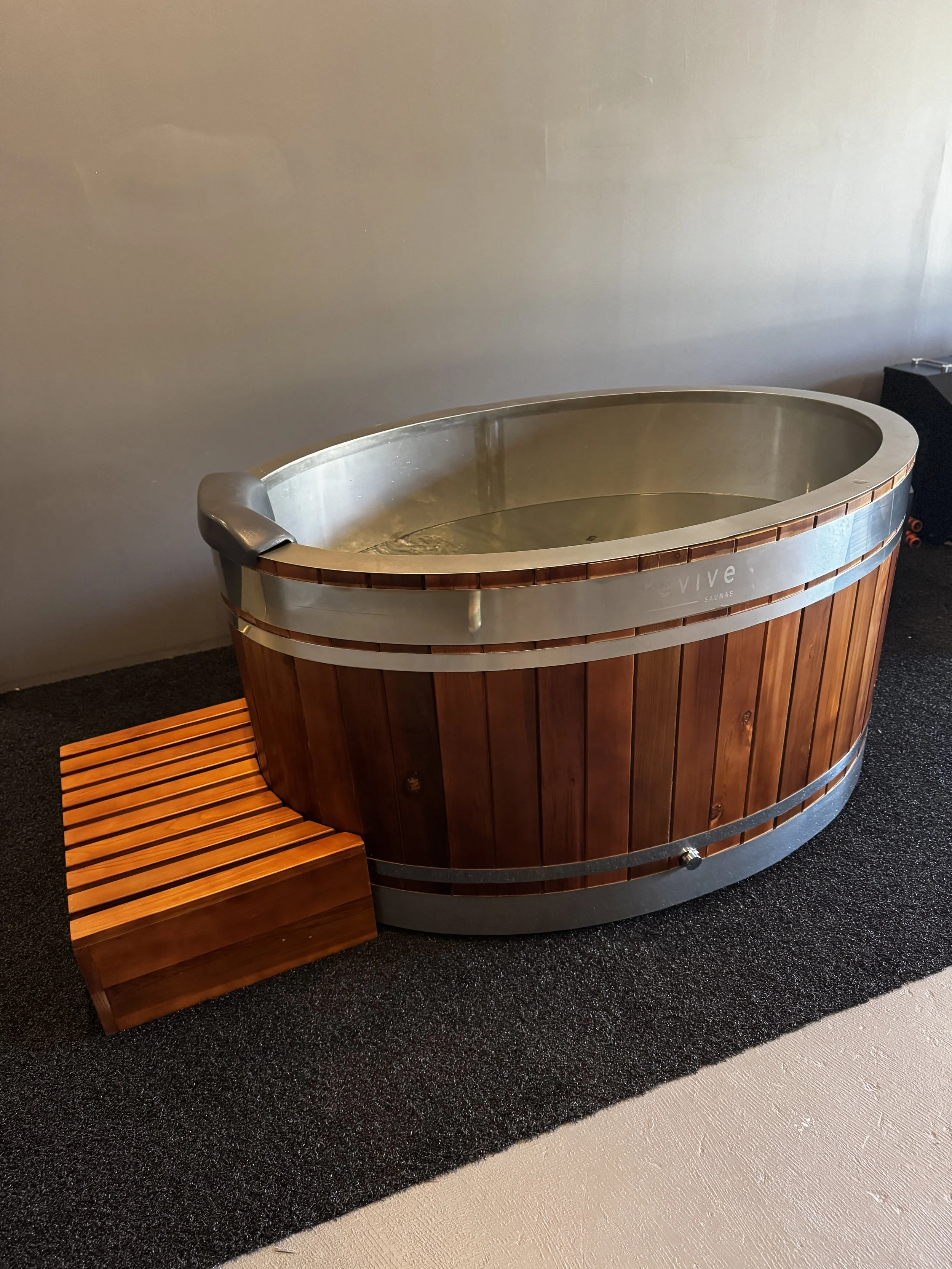 Wooden hot tub with metal interior and steps in a Home Sauna Perth outdoor setup