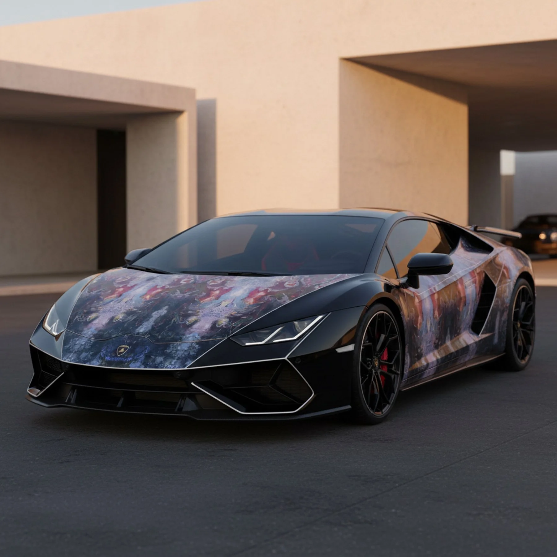 A sleek black sports car with a colorful, artistic wrap sits on a dark street near modern beige buildings with angular shapes.