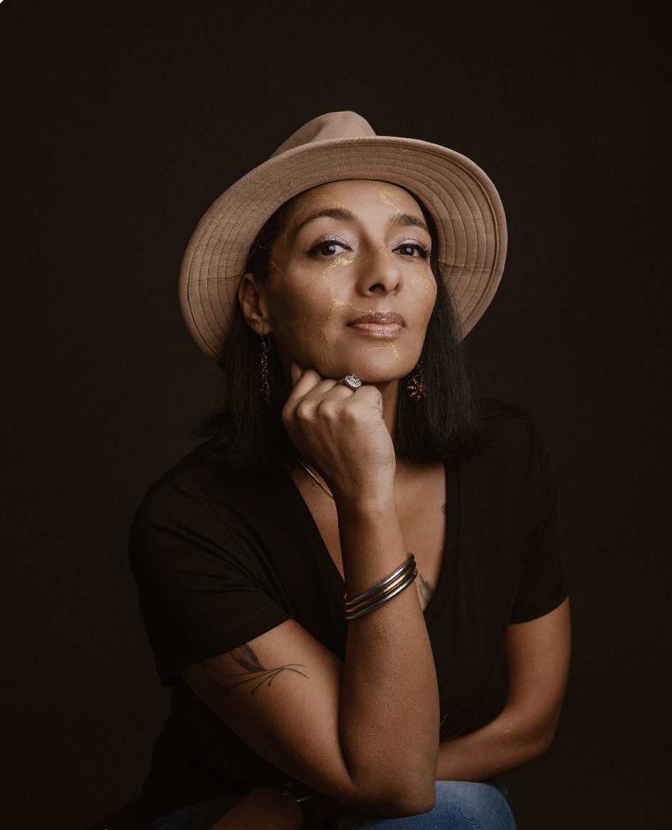 A modern house on a grassy hillside with snow-capped mountains in the background.