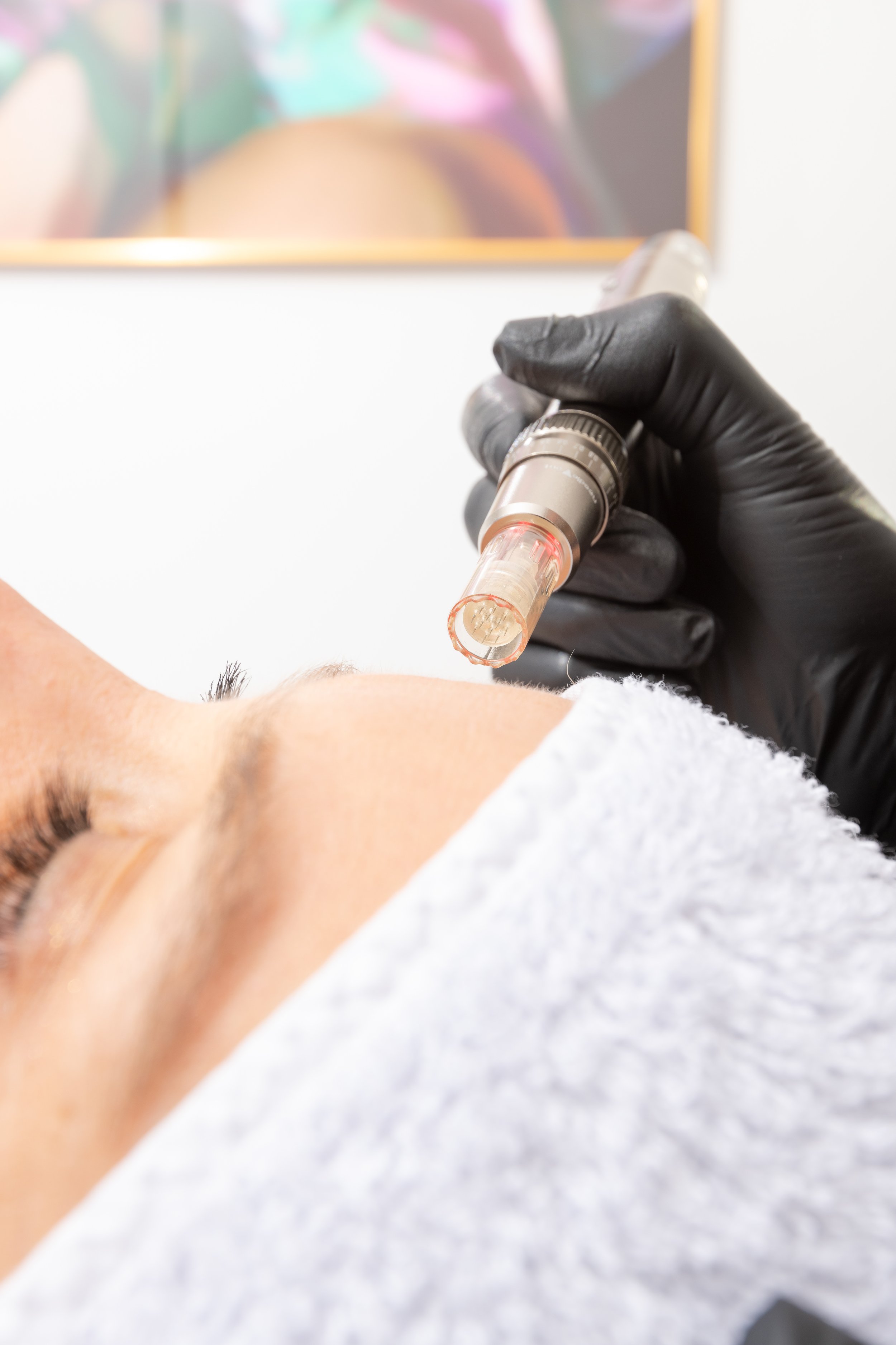 Une personne reçoit une injection lors d'une vaccination, assurée par un professionnel de santé portant des gants noirs.