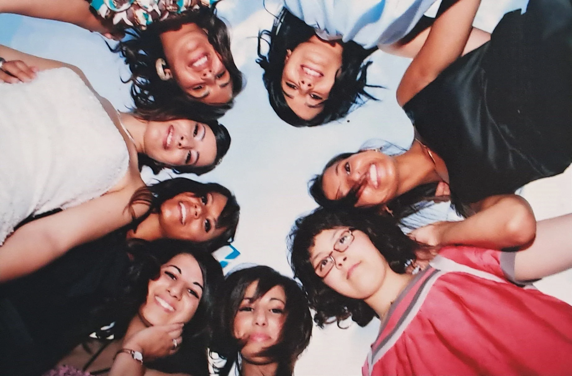 Groupe de neuf jeunes femmes souriantes, prises en selfie, regardant vers le haut.»